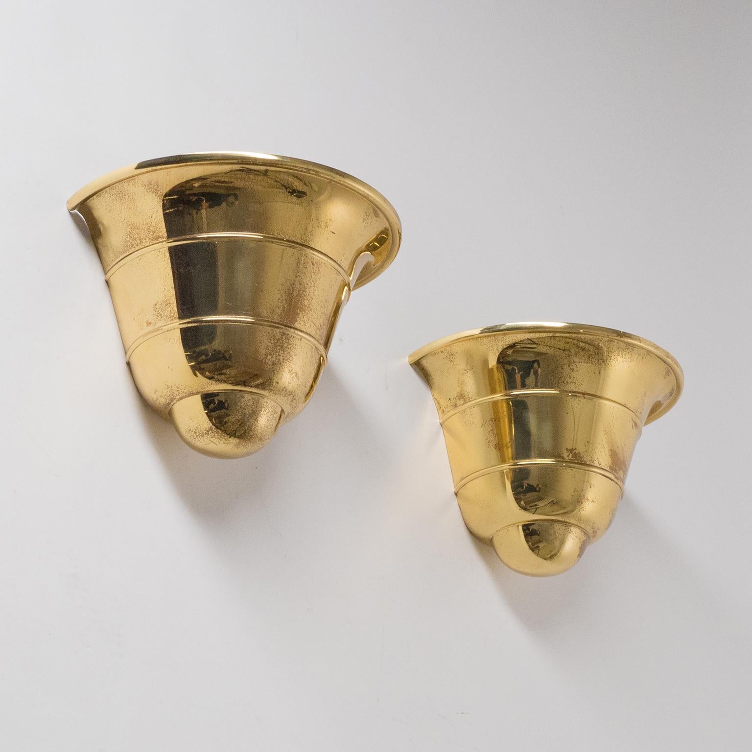 Rare pair of Art Deco brass upligth sconces by WMF Ikora, 1930s. Made from a single piece of brass with a tiered silhouette. Nice original condition with patina and one original brass and ceramic E27 socket each. Manufacturers stamp on each