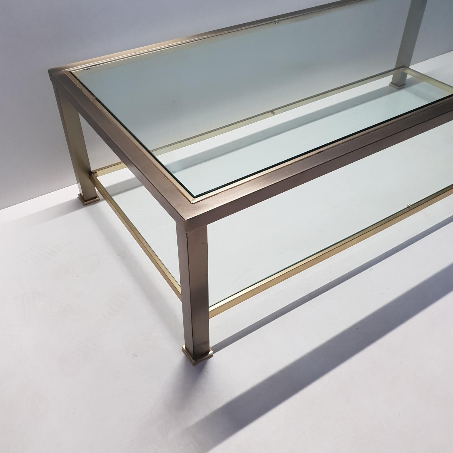 Brass 2-tiers coffee table with cut glass.
Made by Belgo Chrom, 1980s.

Industrial and Hollywood Regency style.