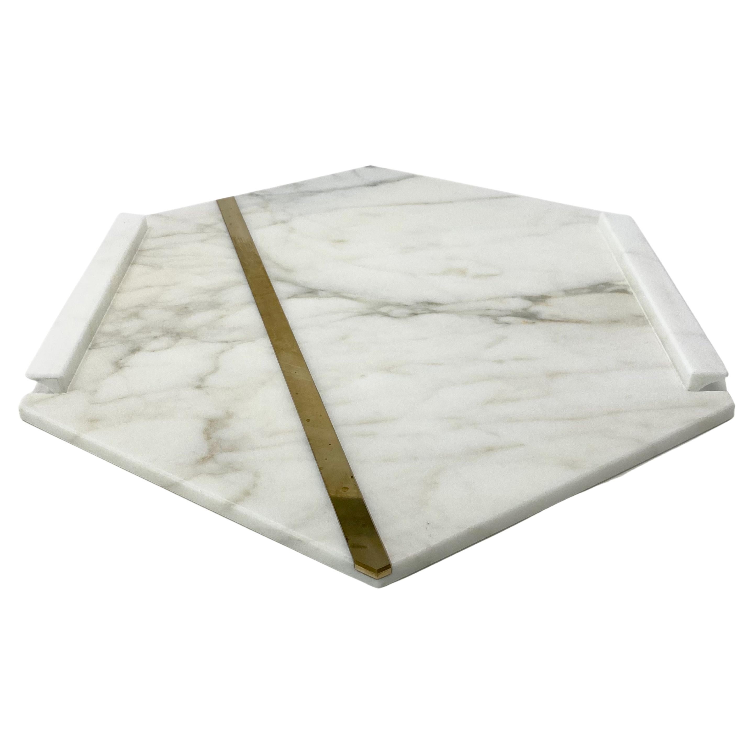 Le plateau Brass, entièrement réalisé en marbre, est un plateau exclusif en Calacatta Oro orné d'une patte en laiton qui parcourt l'objet d'un bout à l'autre, lui conférant ainsi une touche supplémentaire de style raffiné.

Le plateau en laiton fait