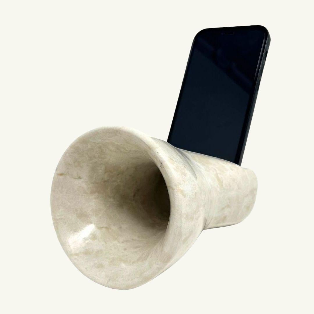 Der Brass-Verstärker, komplett aus Botticino Light Marmor gefertigt, ist ein exklusives und elegantes Designobjekt, das als passiver Verstärker für Ihr Smartphone dient. Um dieses Objekt zu benutzen, schalten Sie einfach die Musik auf Ihrem