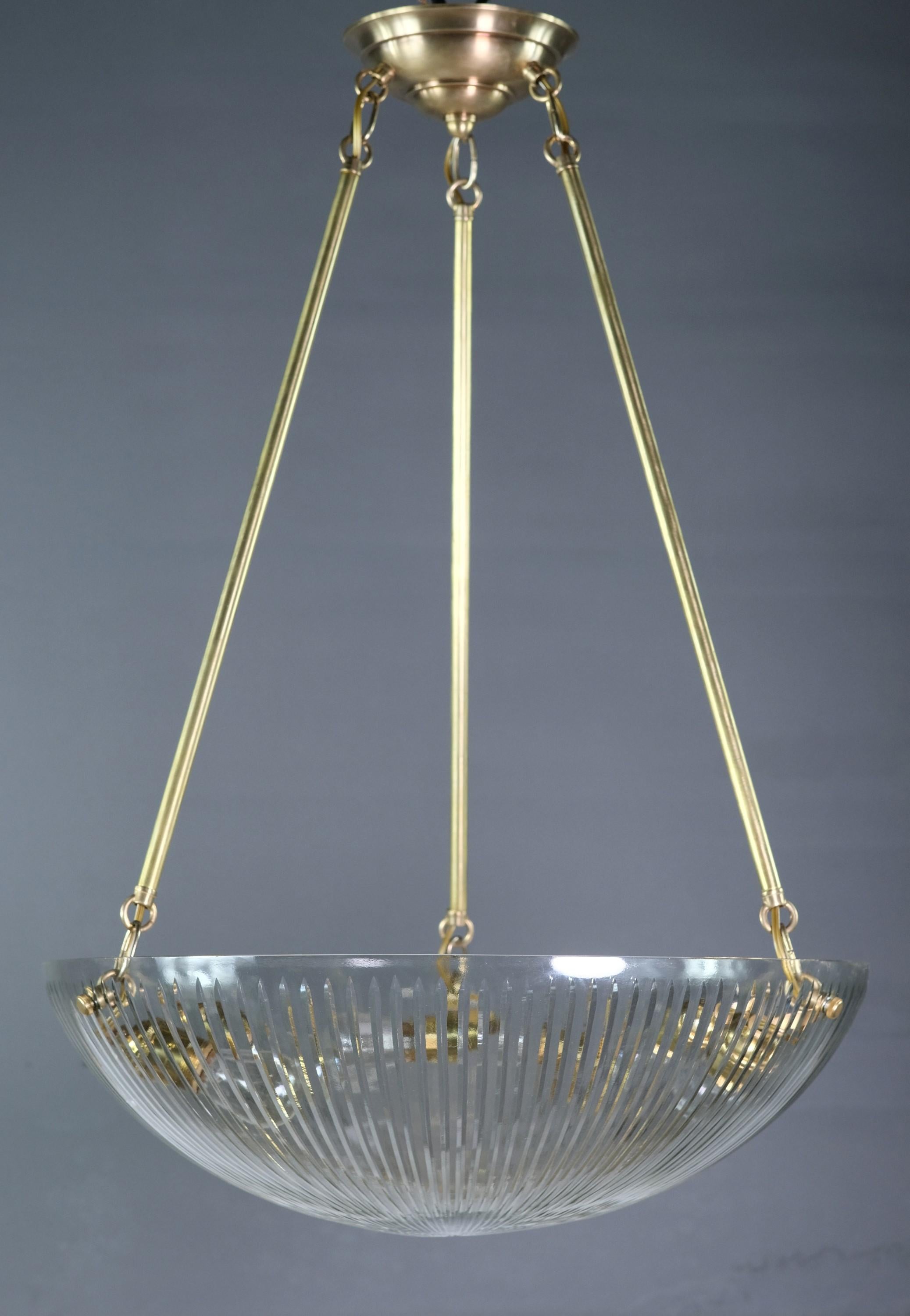 Lampada a sospensione della fine del XX secolo con tre gambe montate su un pesante paralume in vetro trasparente. Contiene tre lampadine standard E26. Questo può essere visto presso la nostra sede di 400 Gilligan St a Scranton, PA.
