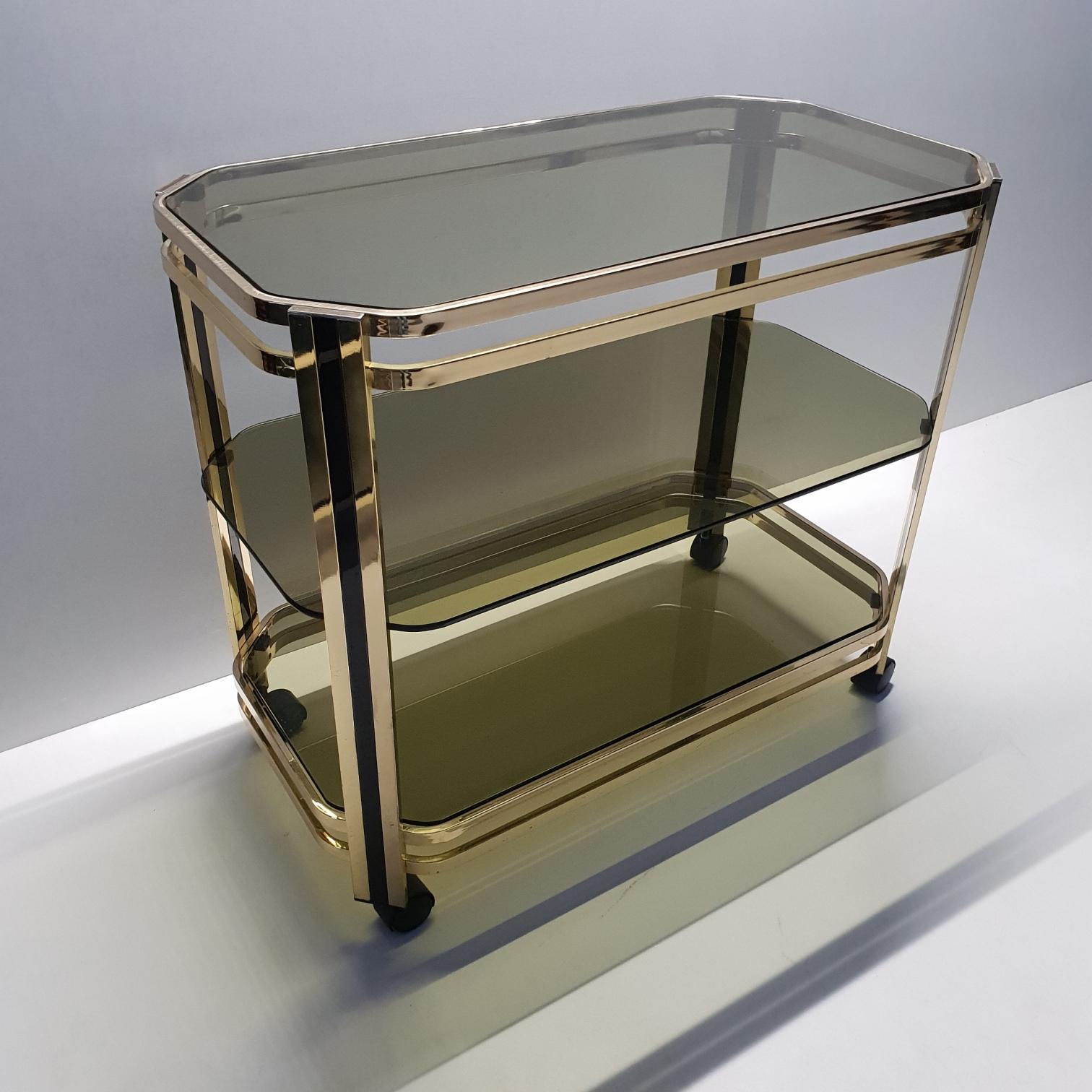 Brass 3-tier serving trolley bar cart with original mirror, 1970s
The trolley has two colors brass and green smoked glass plates.

Measurements mirror: 55 x 80 x 2 cm.