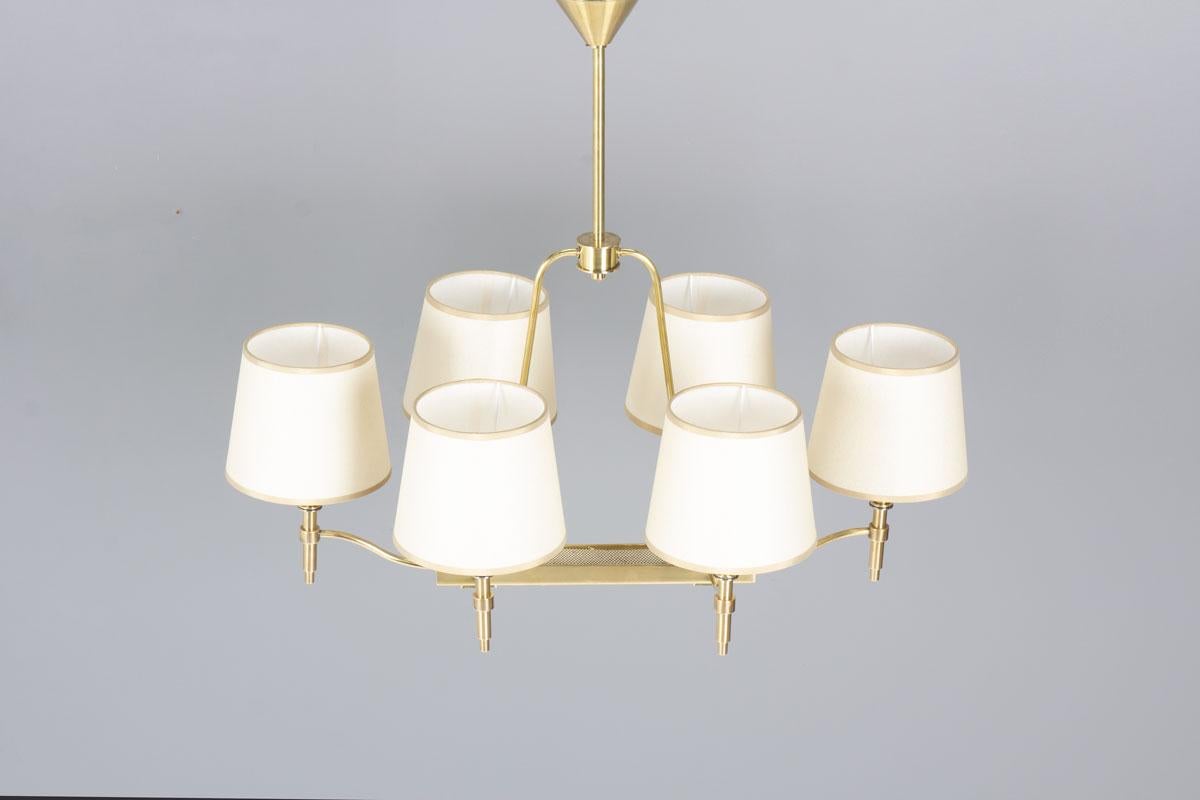 Uno squisito lampadario a 6 luci in ottone della stimata casa di illuminazione francese PETITOT, risalente agli anni Quaranta. Questo pezzo vintage incarna l'eleganza senza tempo e la raffinata maestria per cui Petitot è rinomato.

Il lampadario