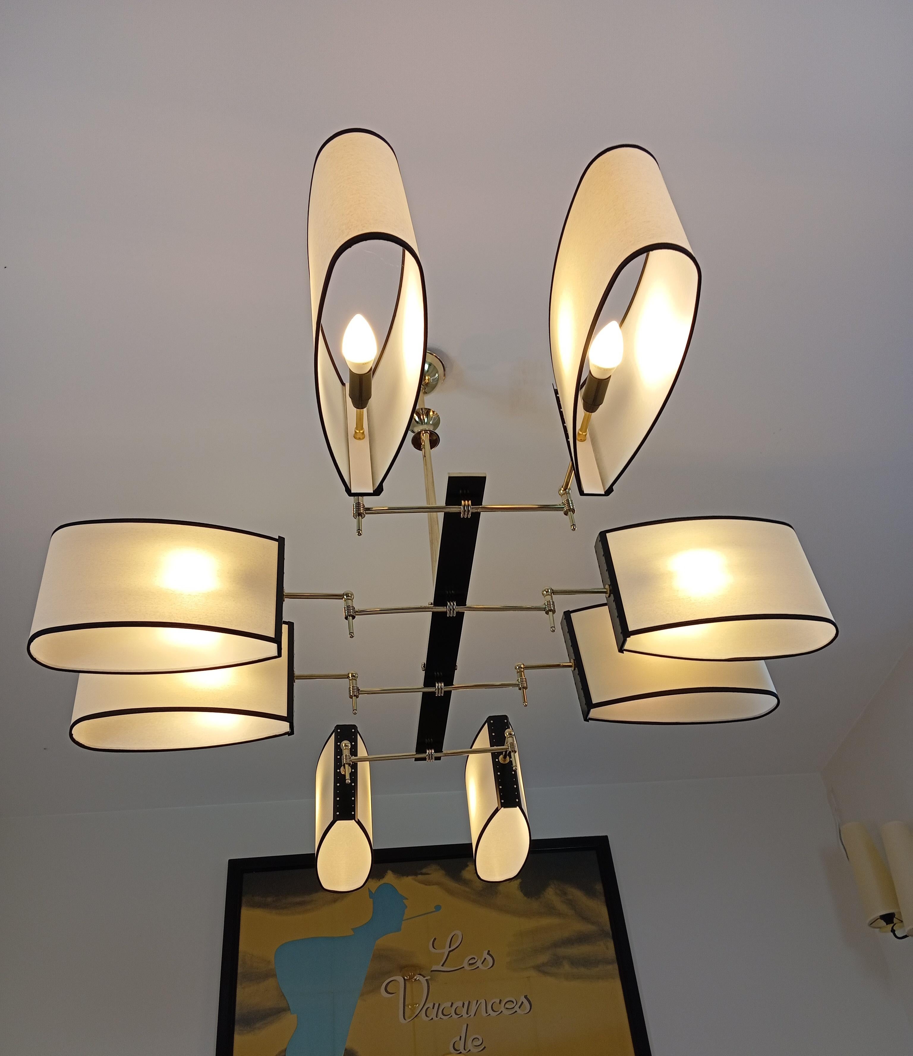 Brass chandelier, consisting of a rectangular, black-lacquered brass base; on which are fixed 8 brass light arms supporting oval shades.
This chandelier has been entirely restored, shades redone to model, new wiring to EU standards.
Possibility of