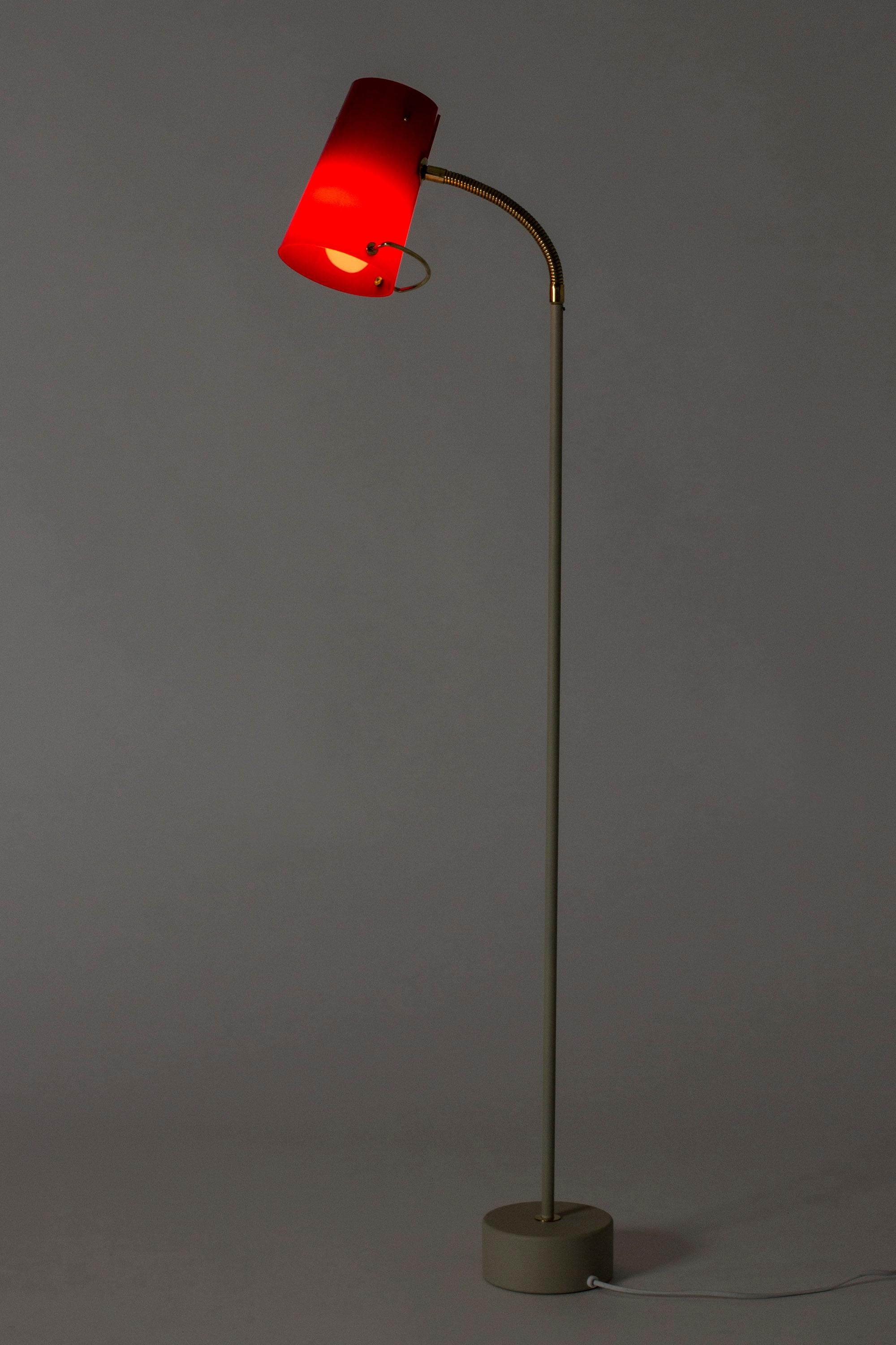 Sleek floor lamp by Hans-Agne Jakobsson, made from light grey lacquered metal. Cherry red shade with brass details, flexible brass neck. Very cool combination of materials.
