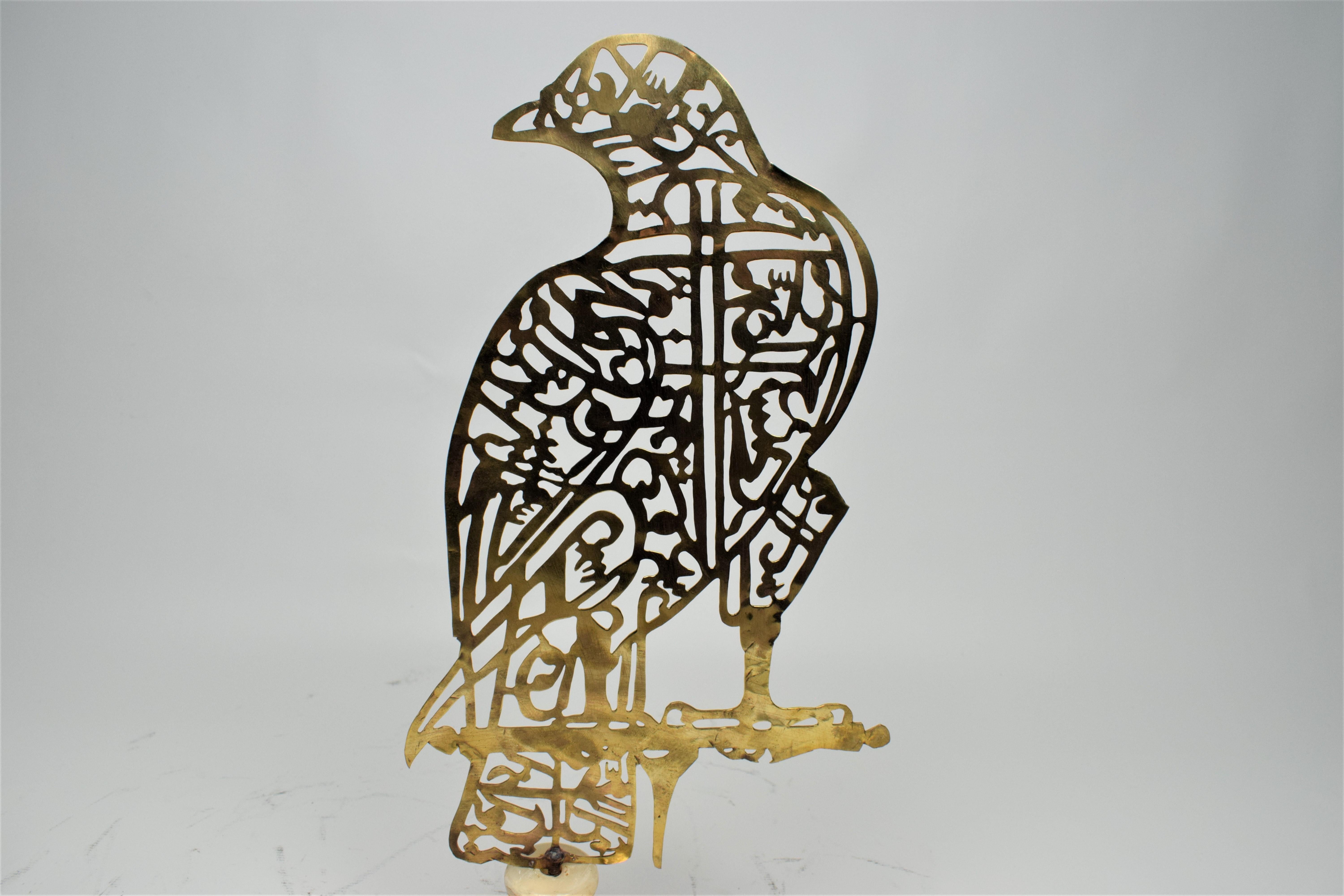 Brass Alam Persian hand Cutwork Calligraphy in the shape of a falcon, 20th century.

The ornamental calligraphy arranged within a frame of a bird of prey -The Falcon. The letters are those of the Shia Muslim prayer, the Nad-i-Ali, or 'Call to