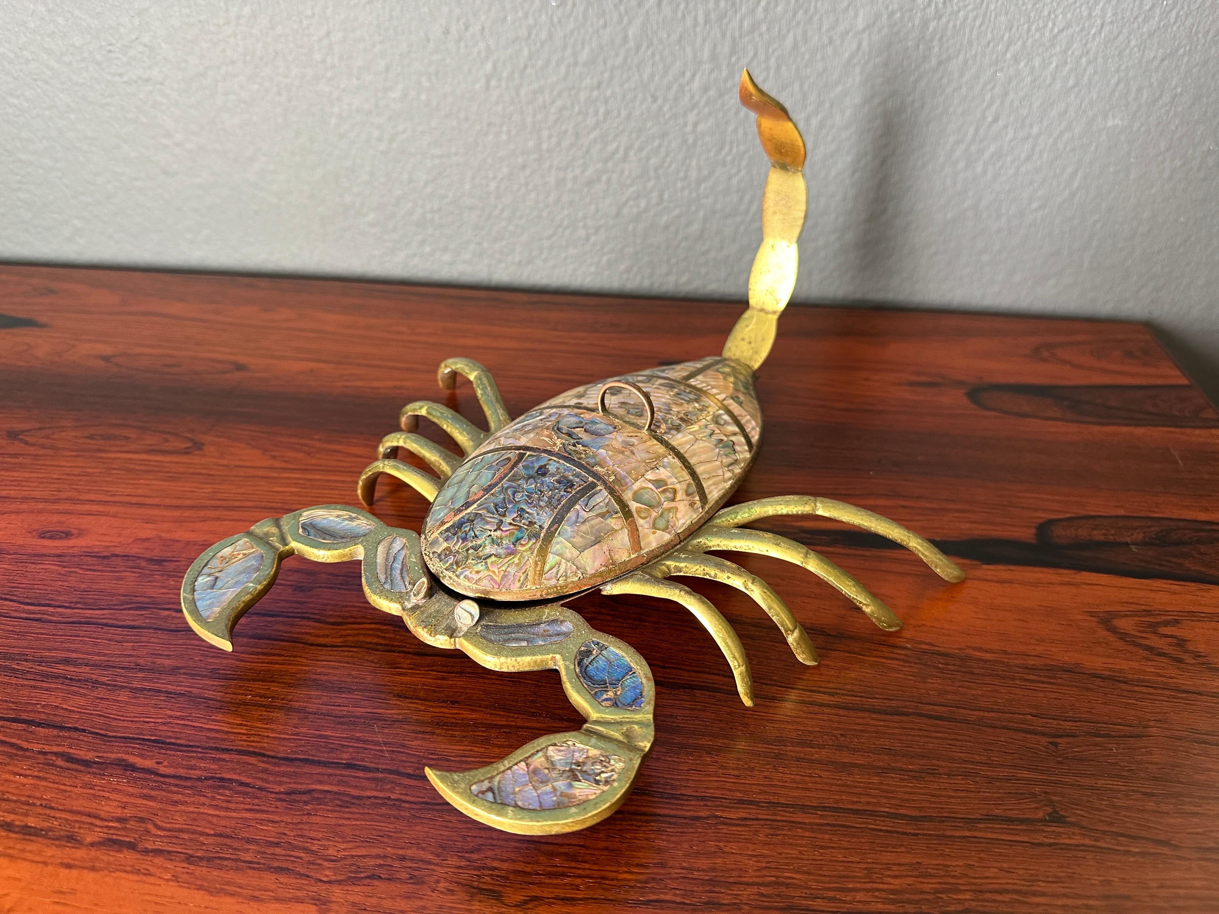 Brass scorpion sculpture trinket box inlaid with beautiful abalone shell made in Mexico attributed to Los Castillo. 
Overtime usually the lid gets broken or lost but this one is in complete condition.
Two available. Priced individually.