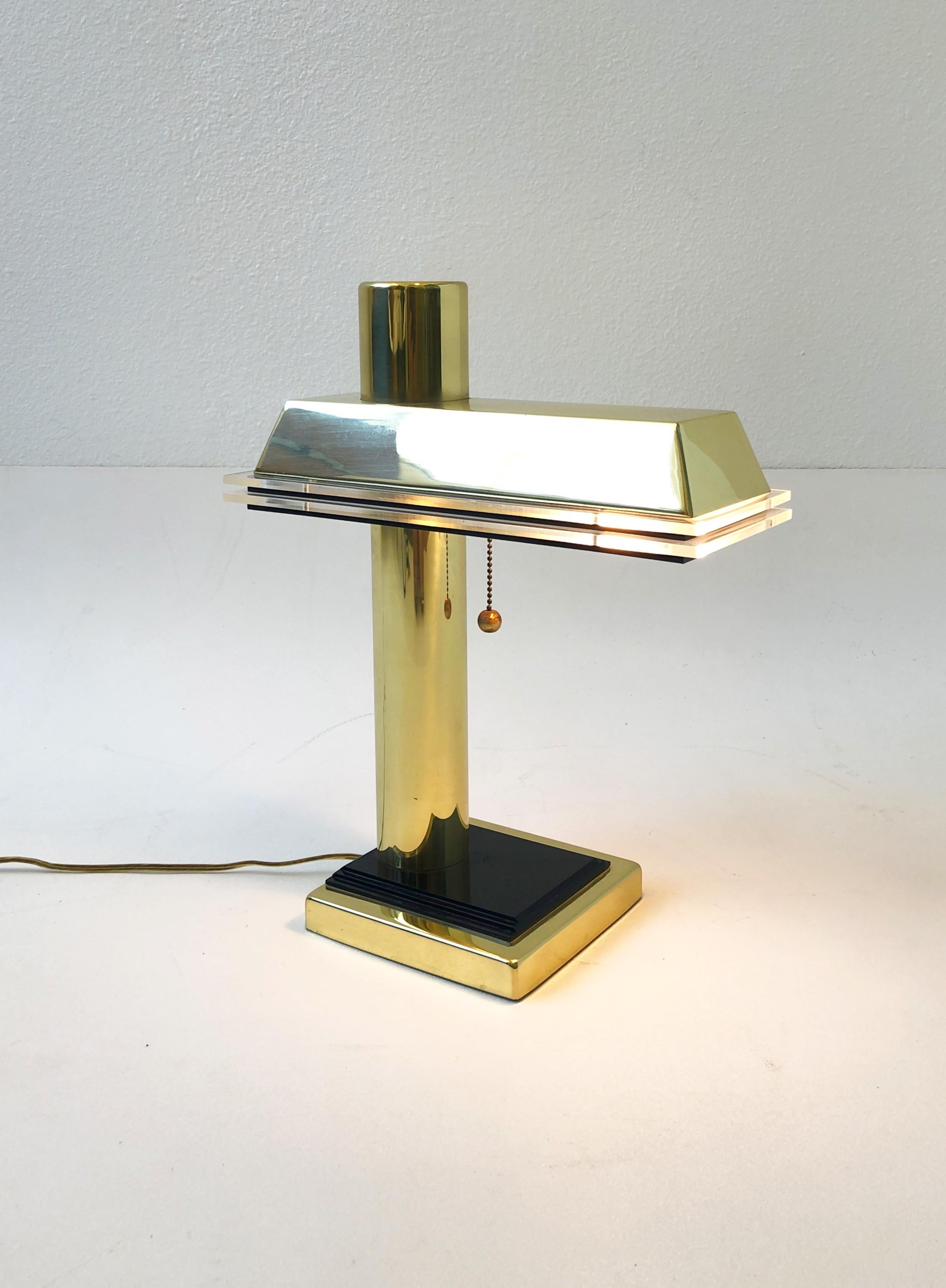 1980’s polish brass with clear and black acrylic detail desk lamp. 
It takes one regular Edison lightbulb with pull down on/off switch. 
Measurements: 13.25” wide, 6.5” deep and 16.5” high. 
Base is 6.5” wide and 6.5” deep.