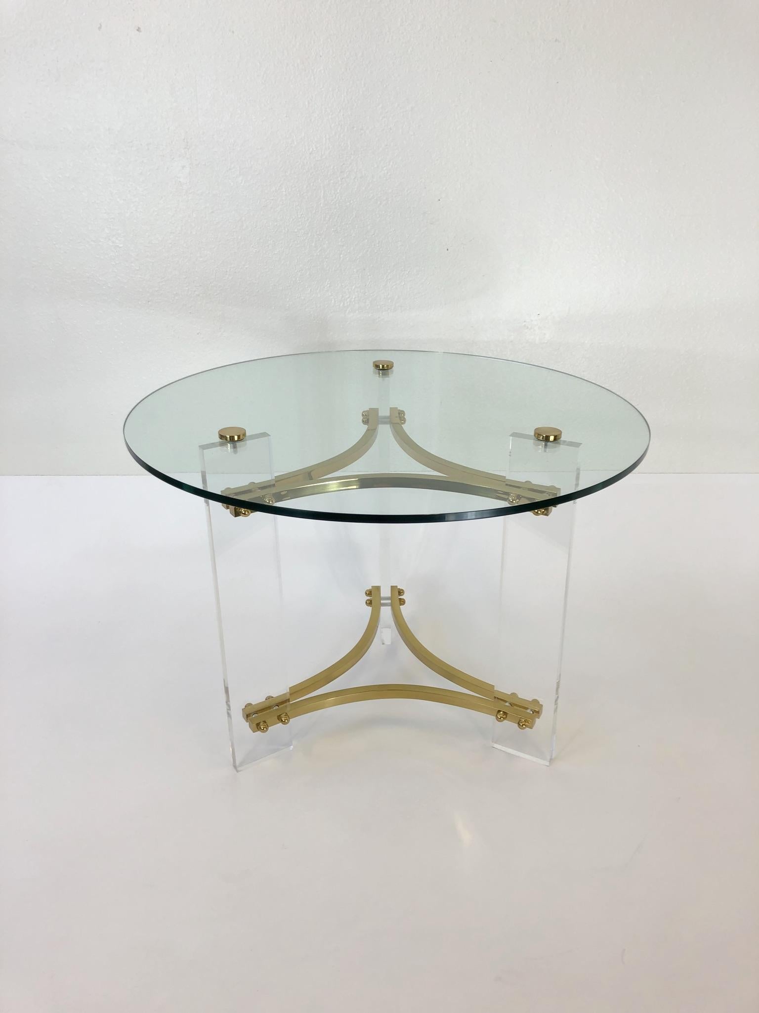 A glamorous polish brass and clear acrylic with glass top side table designed by Charles Hollis Jones in the 1970s. 

Dim: 20.5” high 28” diameter