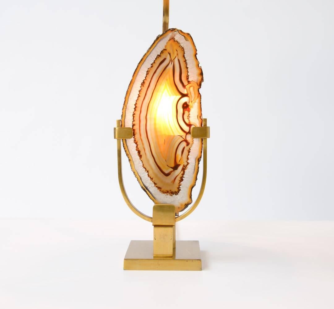 This magnificent brass table lamp was designed by Willy Daro in the 1970s.
The brass base holds the beautiful mineral agate stone (24 x 11 cm). It is a unique piece. The agate stone is illuminated on the back.
This lamp is in very good condition