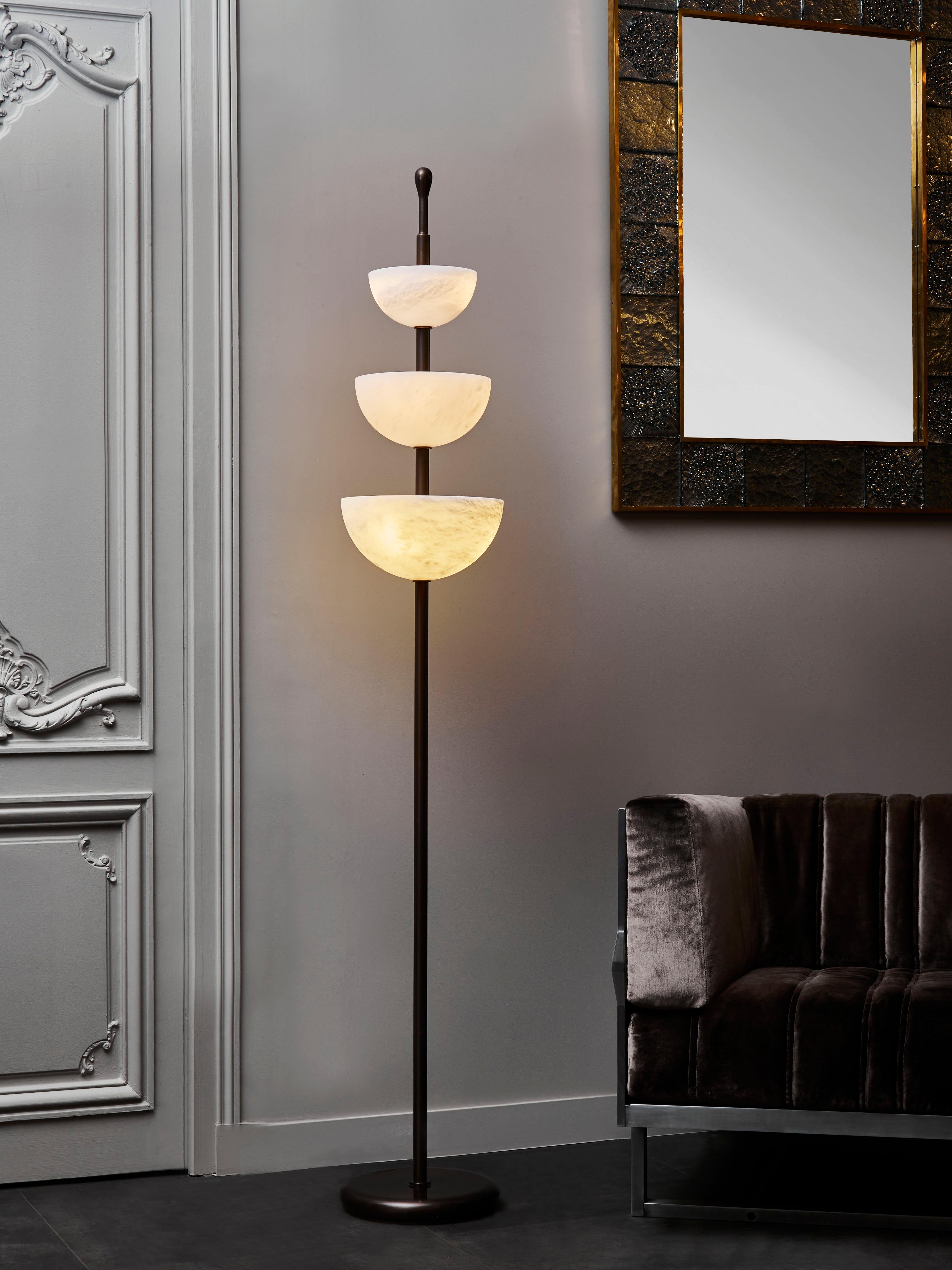 New design by Glustin Luminaires, these floor lamps are inspired by our three cups suspension.

Brass foot with a light bronze patine, holding three different sized alabaster cups.

Each bowl host between two and three light bulbs hidden by a