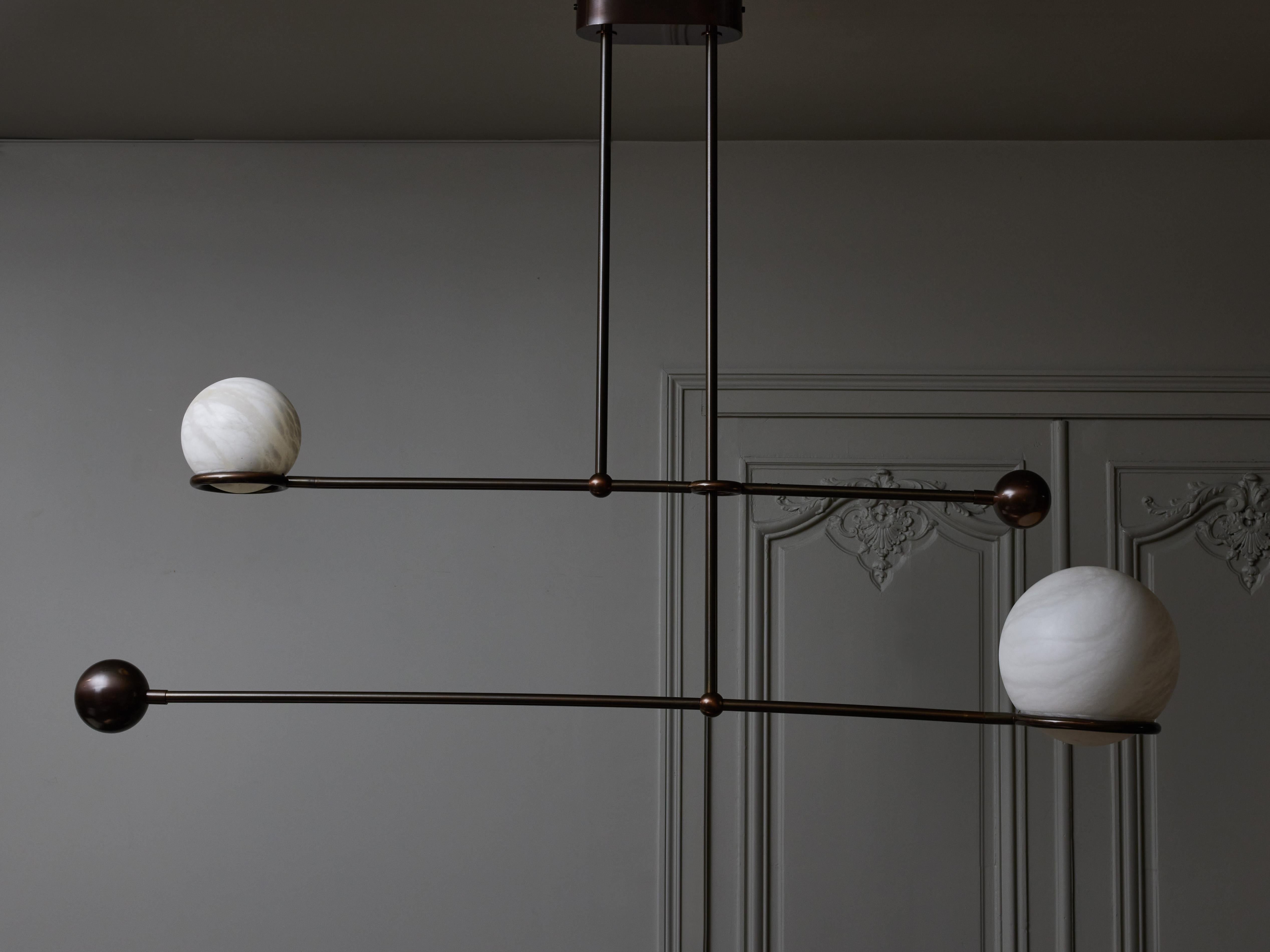 Double pendulum chandelier by Glustin Luminaires, made of a brass structure in light bronze finish and two alabaster globes diffusing the light.