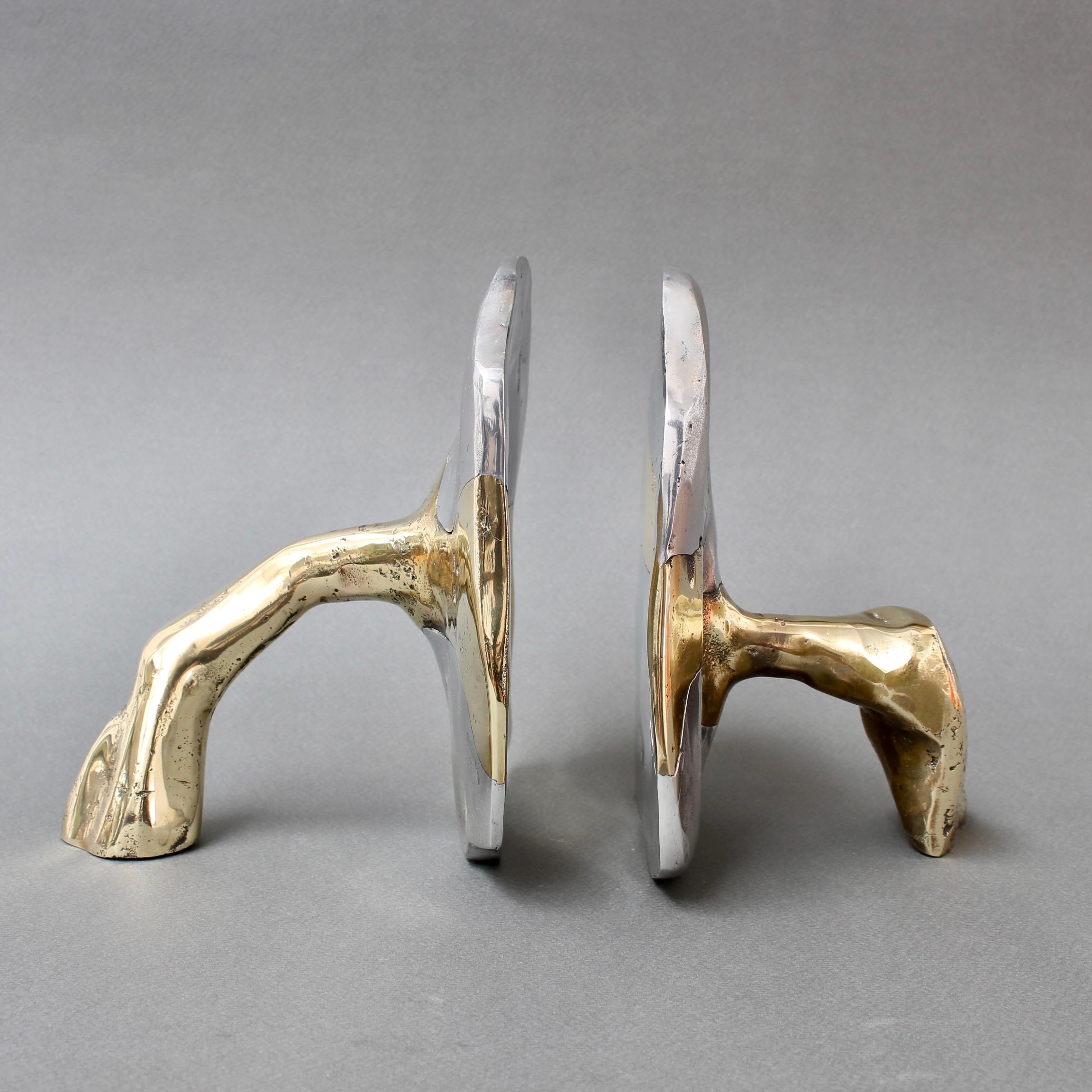 Brass and aluminium Brutalist style bookends by David Marshall (circa 1980s). These are weighty, cratered and raw as if plucked right from nature. The brass support pieces meld with the aluminium seamlessly to form the bookends. Standing alone,