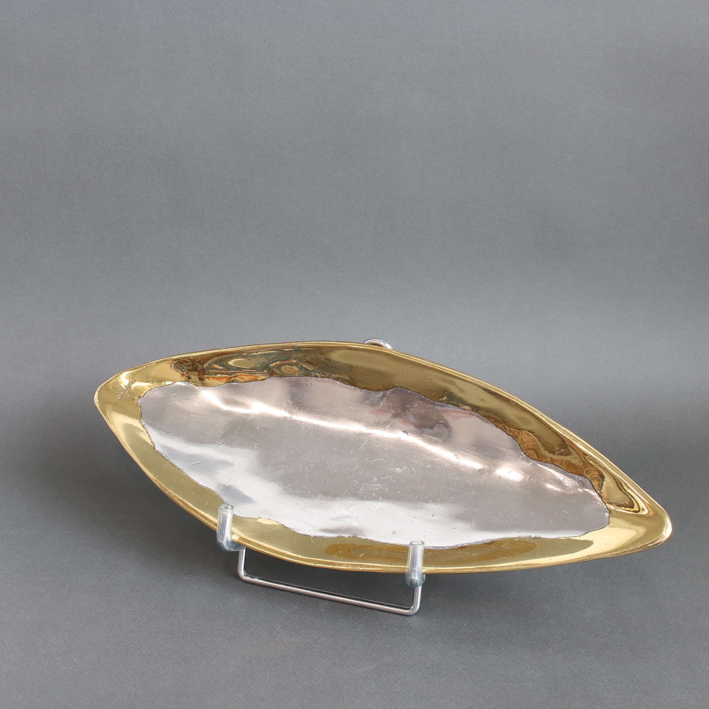 Vassoio a forma di foglia in alluminio e ottone in stile brutalista di David Marshall (circa anni '90). L'alluminio lucido costituisce la struttura di base e l'ottone è presente sui bordi del pezzo. Il marchio del produttore di un tempo è ora una