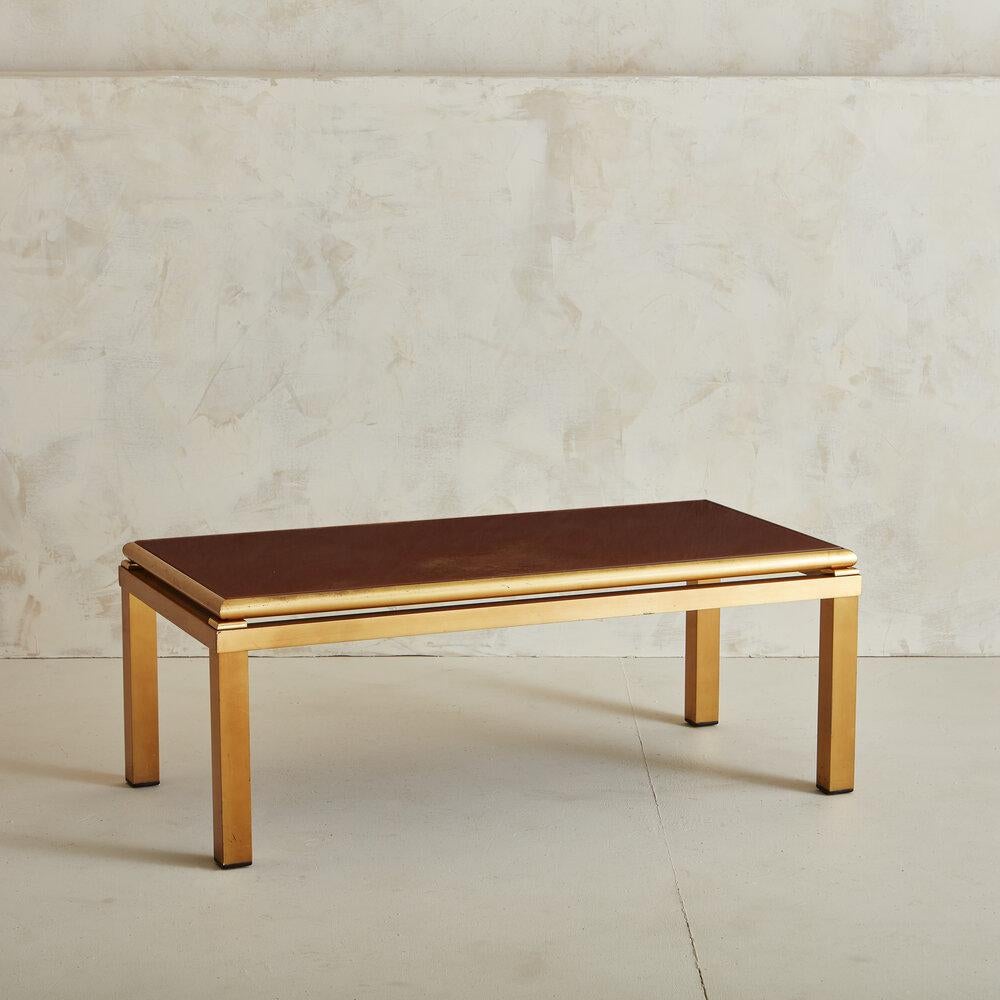A stunning brass coffee table featuring bronze hued back painted glass top. We love this piece for its timeless and elegant design. Attributed to the designer Guy LeFevre, famous for his eglomise glass pieces. France, 1970s.