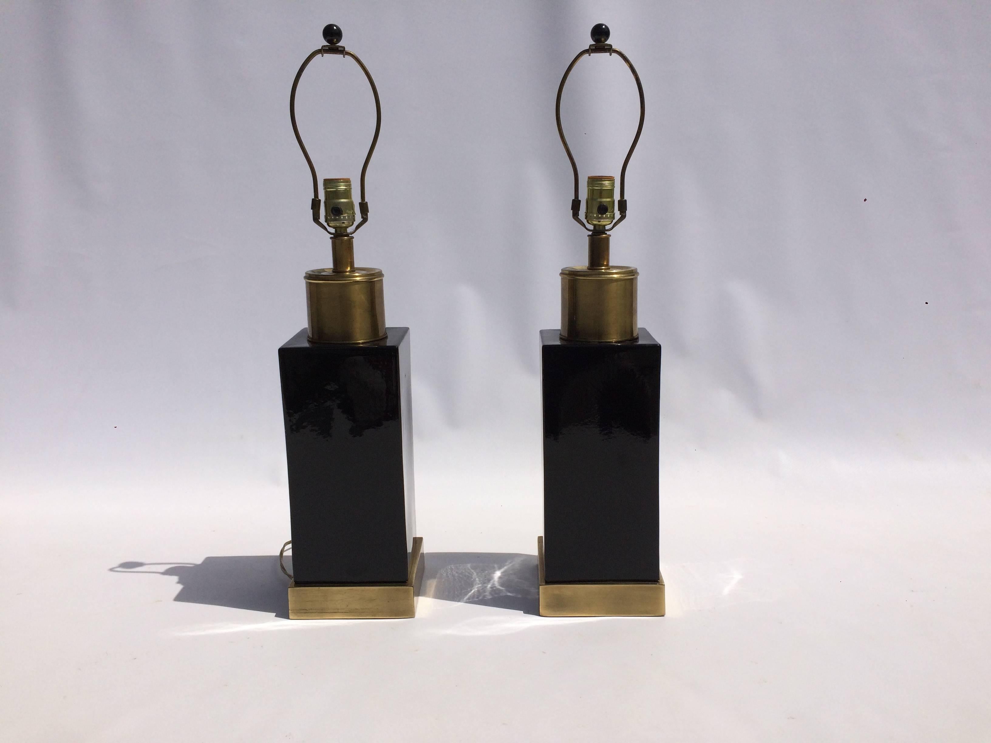 Pair of brass and black painted ceramic lamps with the original black shades.