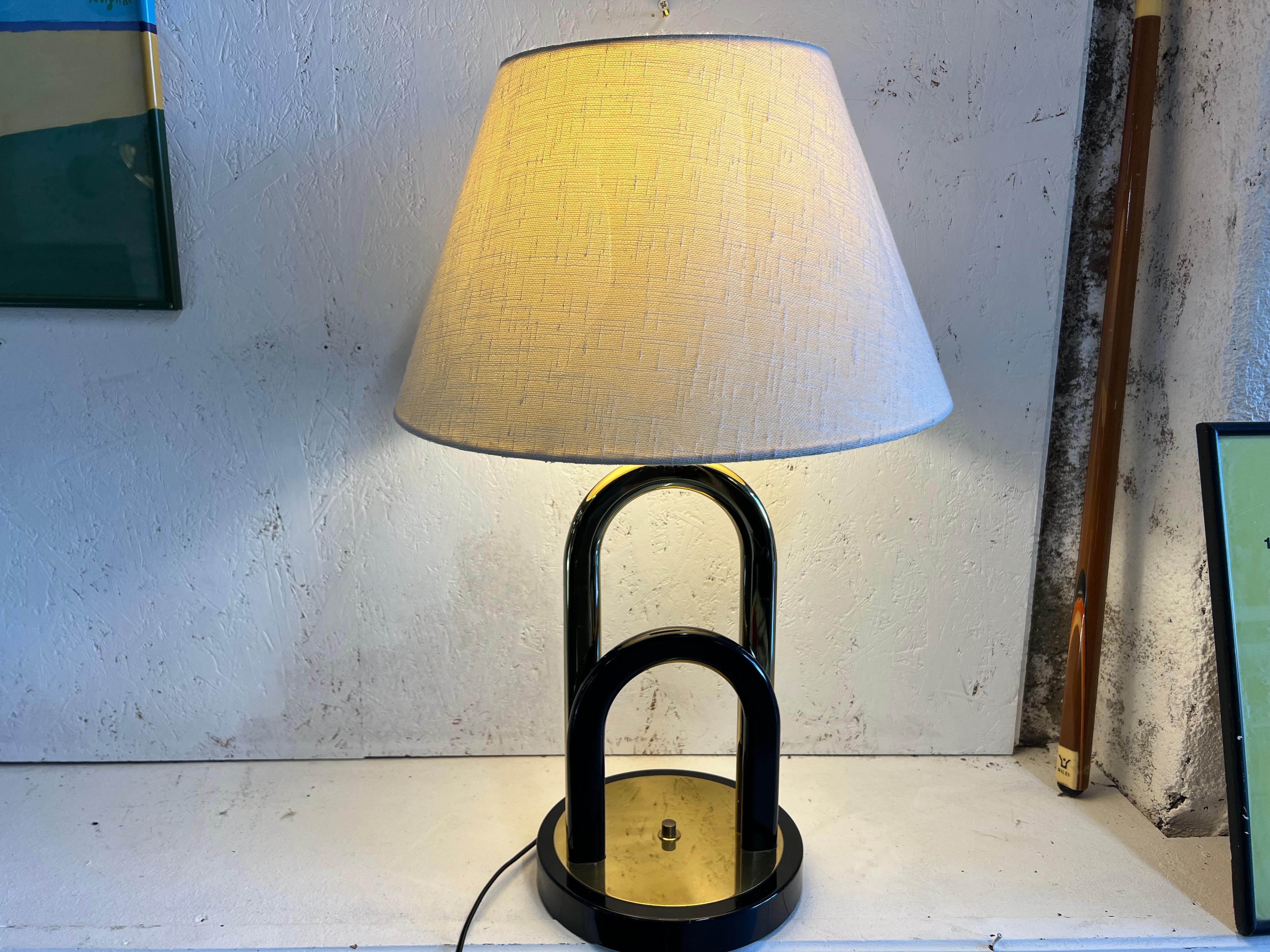 desk lamp in brass and black lacquer from the 80s
the whole thing is in perfect original condition, its lampshade is in natural linen but can be changed as you wish.
the golden brass part is shiny and forms a double arch

