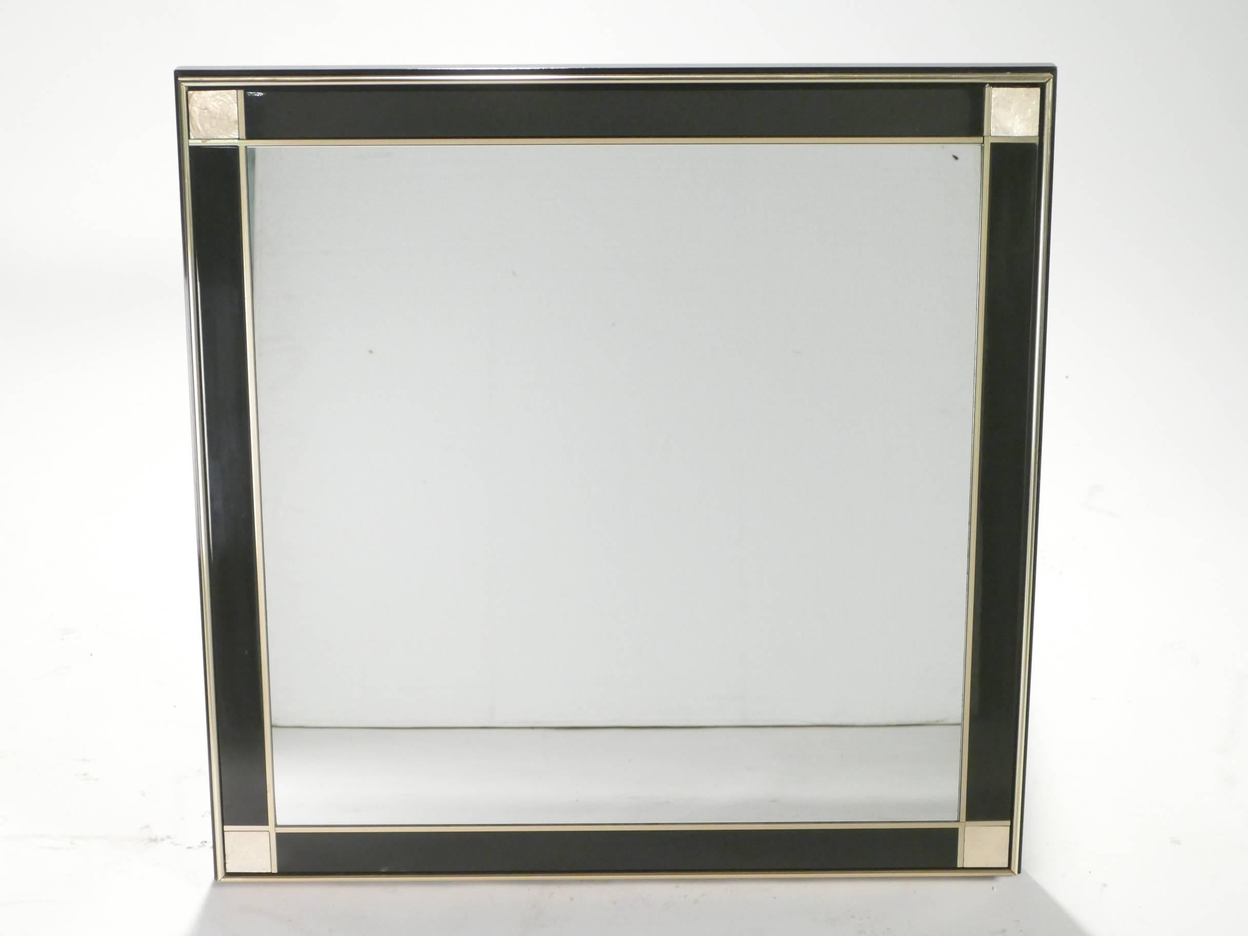This beautiful, rectangular wall mirror is made with high-quality brass and black lacquer. The thin, bright brass lines around the mirror’s border and the brass square panels in each corner create an artsy, geometrical feel about the piece, without