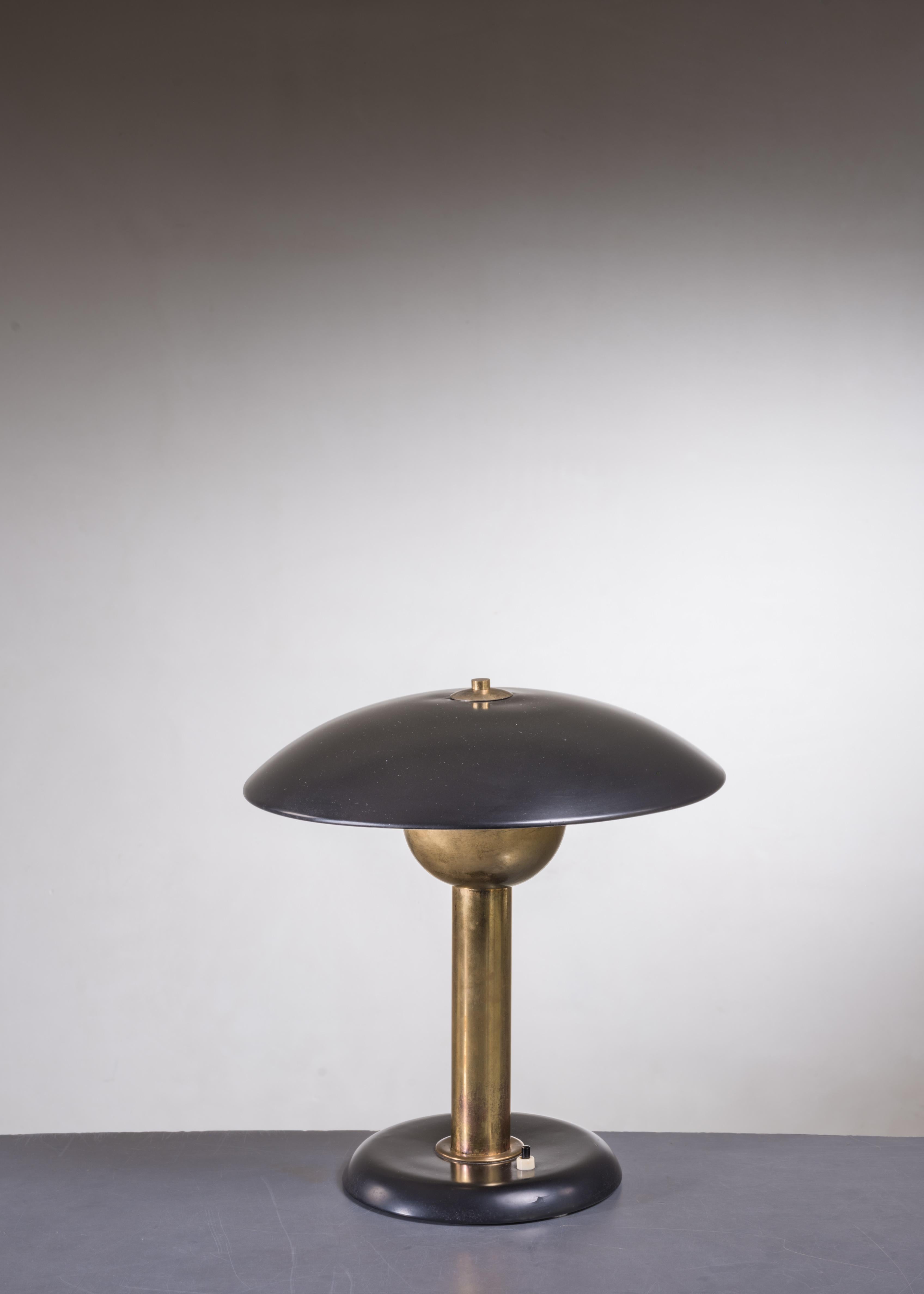 A Modernist Italian heavy brass table lamp with a black metal foot and shade.