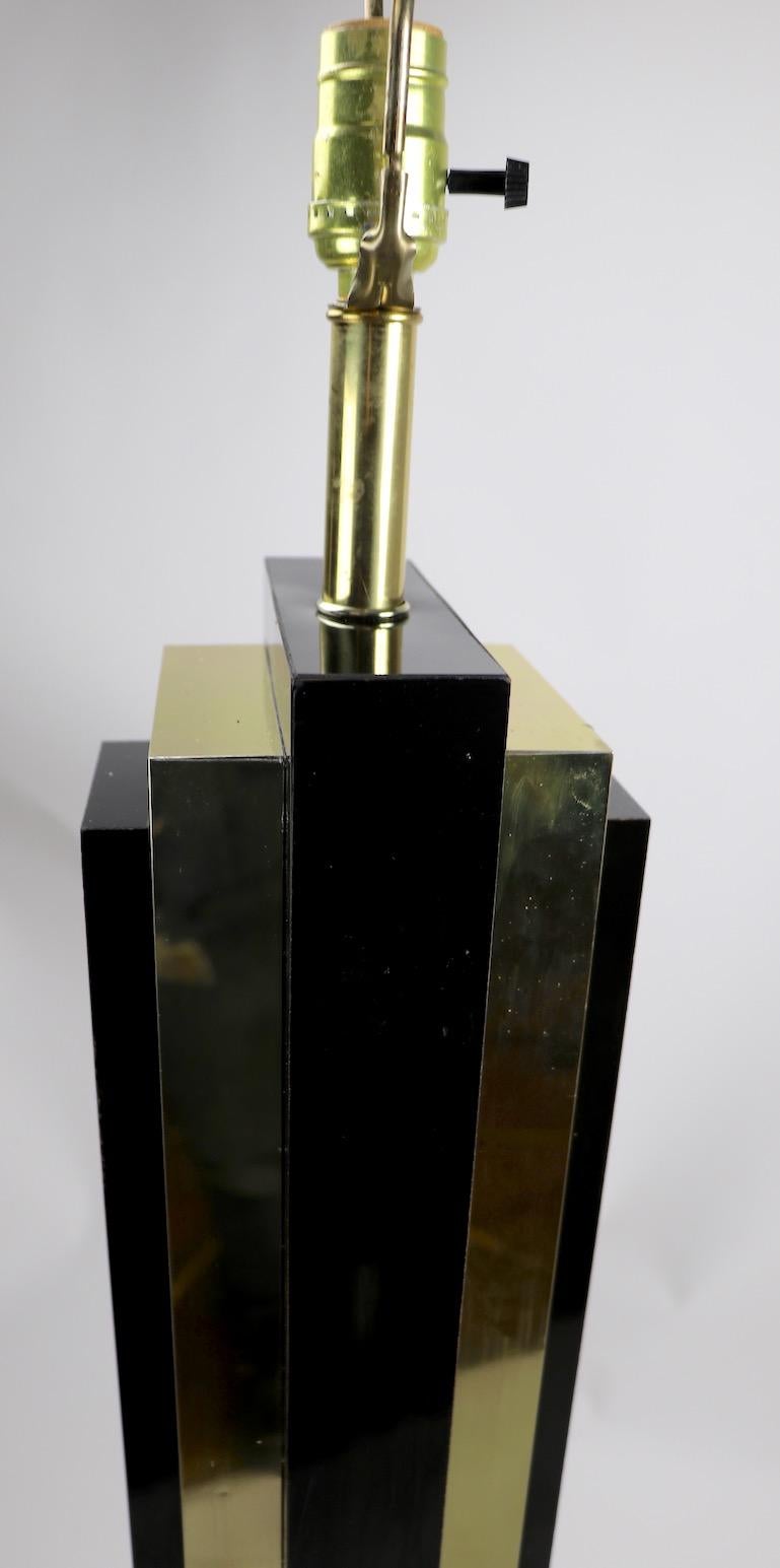 Stylish Art Deco Revival skyscraper style floor lamp. The lamp is constructed of black laminated and brass plated metal elements, in the Art Deco style, manufactured in the 1970s, 1980s. Overall very good, and working condition, base shows cosmetic
