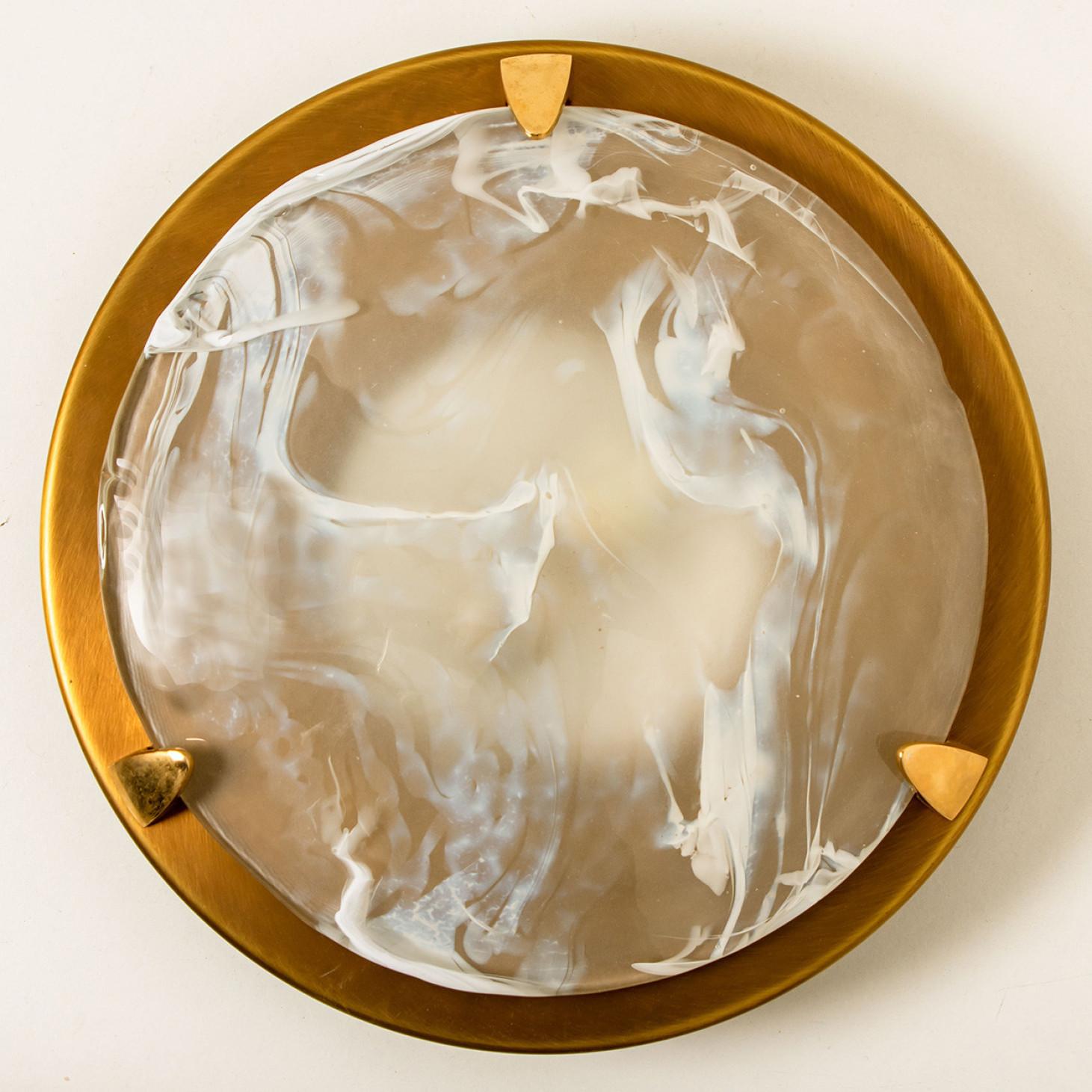 A  stunning high-end brass and Murano glass flushmount manufactured in the late 1960s-early 1970s. The brass ring holds a large heavy blown glass with four brass brackets. The think glass has a beautiful textured structure. With stripes of clear and