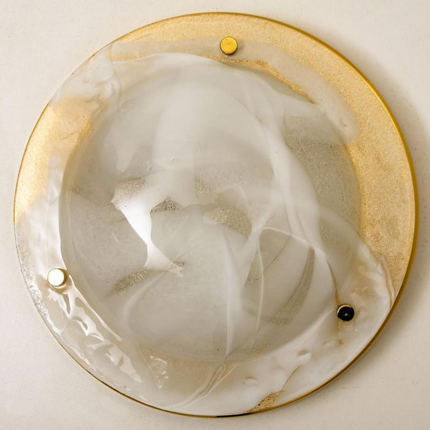 High-end brass and Murano glass wall lights or flush mount by Hillebrand. Manufactured in the late 1960s-early 1970s. The brass ring holds a large heavy blown glass with three brass brackets. The think glass has a beautiful textured structure. With