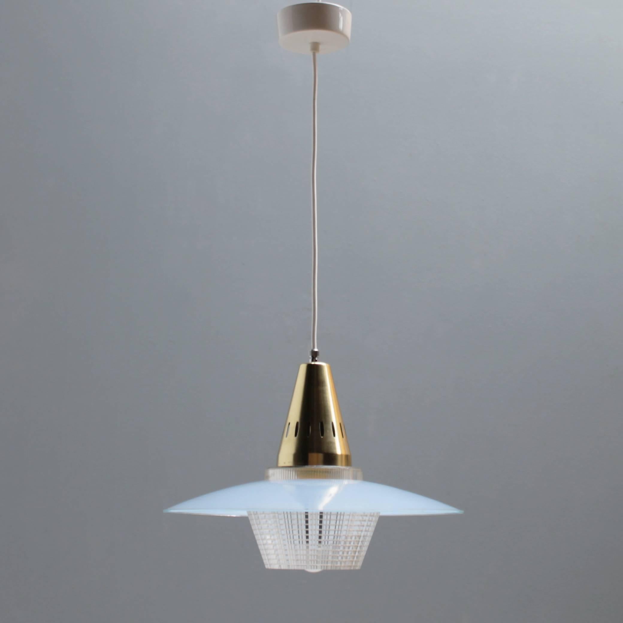 Charming pendant in manner of Stilnovo. Austria or Italian but the design is unknown to me. Blue glass shade with a brass gilt aluminium fixture with a plastic light diffuser. White porcelain canopy.
Dimensions: height 10.2 in. (26 cm), diameter