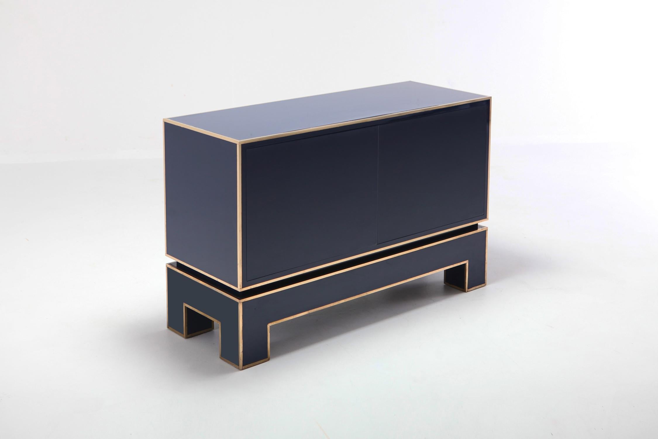 Blue and brass two-door cabinet in Hollywood Regency Italian glam style 
this high end cabinet is finished front to back
stunning piece by Alain Delon for Maison Jansen
would fit well in an eclectic Willy Rizzo, Romeo Rega inspired interior.

 
