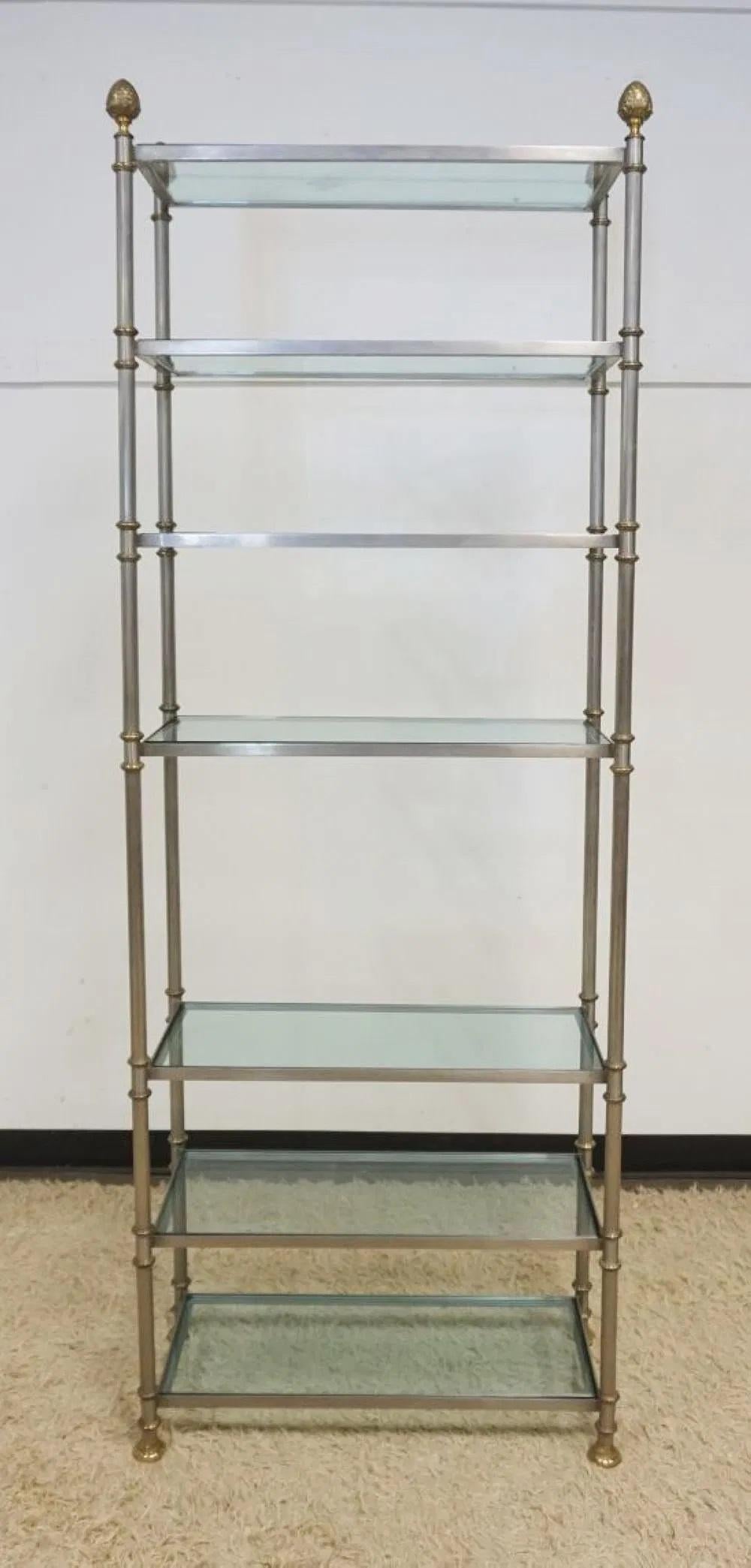 Laiton et brossé  Acier  Etagère  ou Étagères , Maison Jansen , mid  20e siècle.
Il s'agit d'un exemple très solide, de la plus haute qualité, avec 7 étagères en verre, un support de colonne en acier brossé, des épis de faîtage en laiton, des