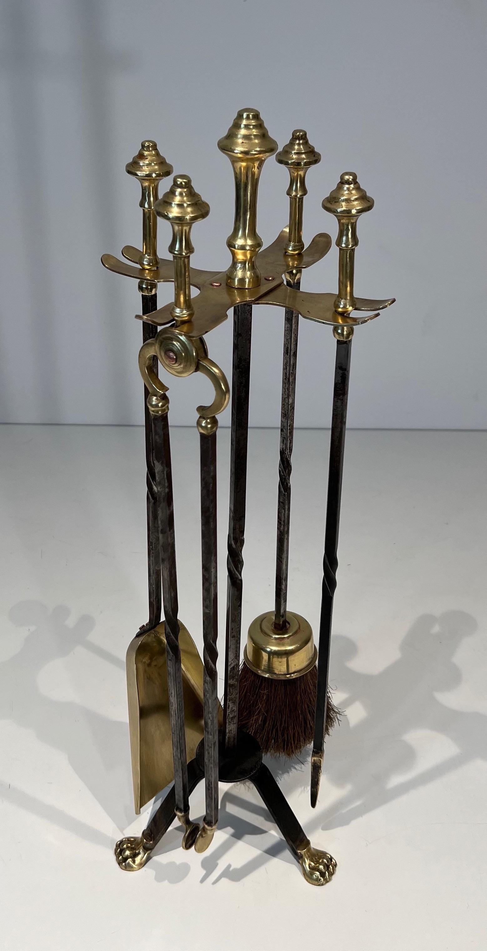 This very nice and rare neoclassical style fireplace tools on stand is made of brass and brushed steel . This is a French work attributed to Maison Jansen. Circa 1940