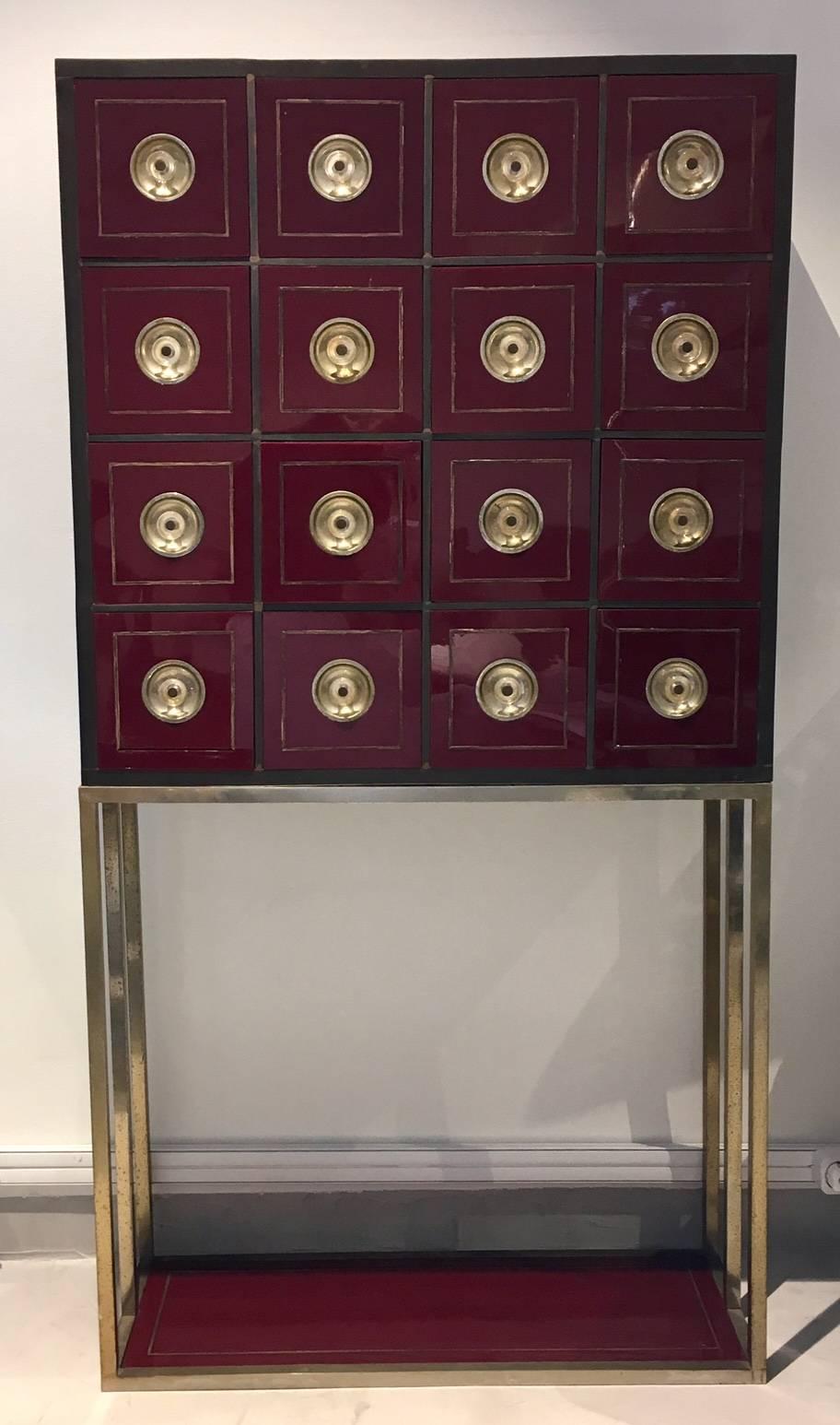 Rare burgundy red cabinet in the style of Willy Rizzo with 16 drawers. Patinated metal structure, red acrylic coated wood and brass applications.