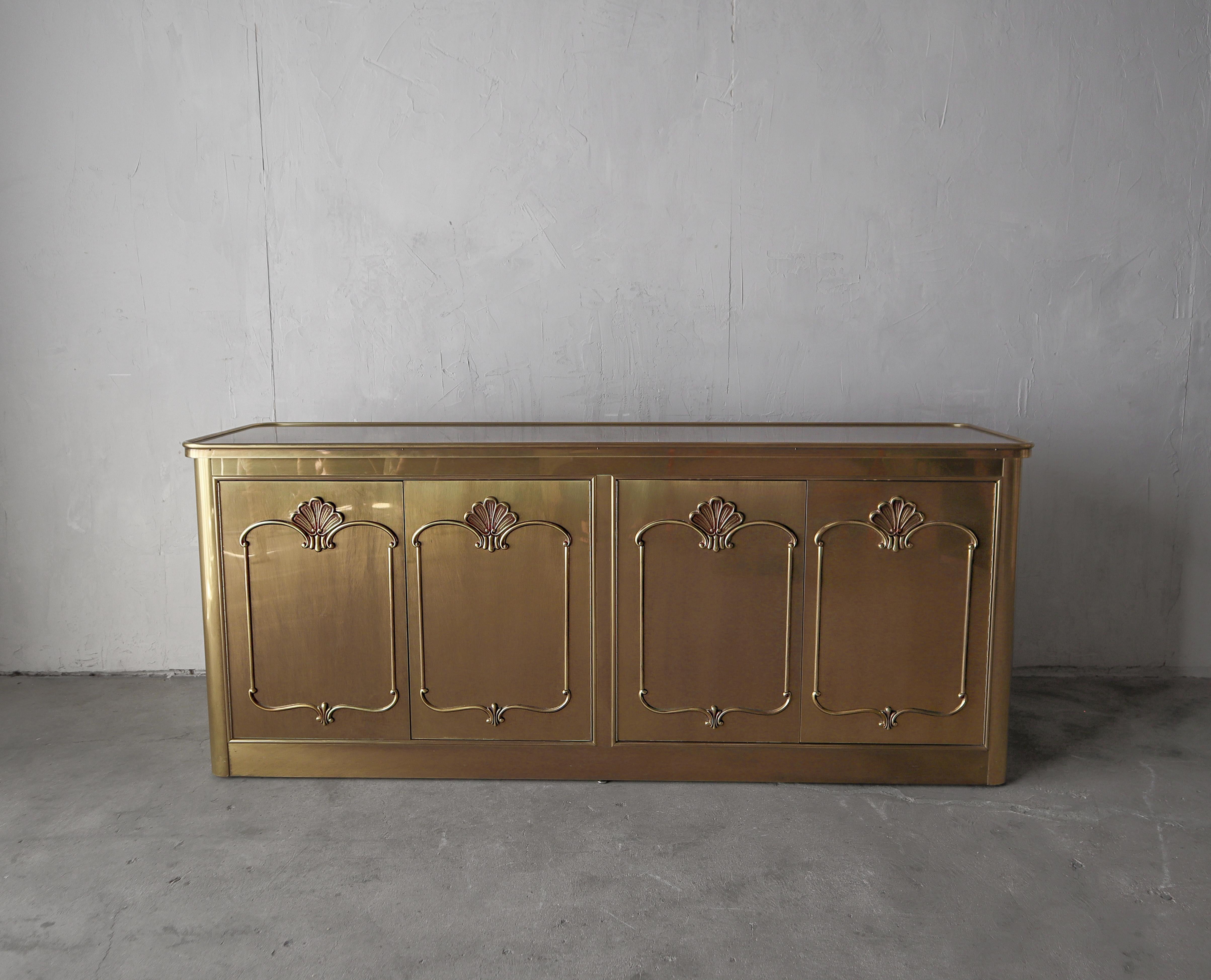 Beautiful brass-clad credenza by Mastercraft with a burled top and dimensional details on the doors.

The cabinet is in excellent condition with no real imperfections to be noted.  Installation ready.