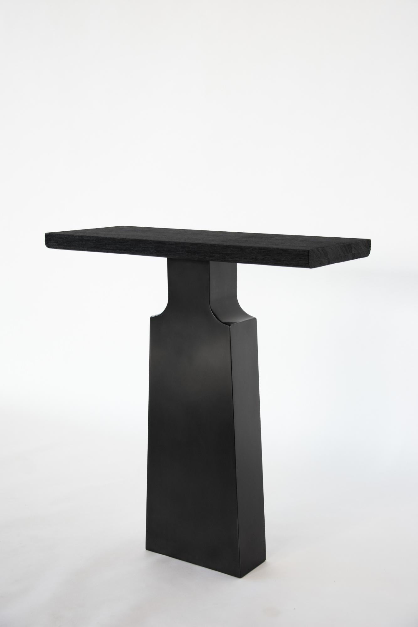 Burnished Steel & Burned Wenge Liah Console Table by Eichkorn
Dimensions: W 85 x H 93 cm
Materials: Burnished steel, Wenge wood. 

Liah unites refined elegance with powerful materiality. Its patinated steel base supports a charred, brushed tabletop