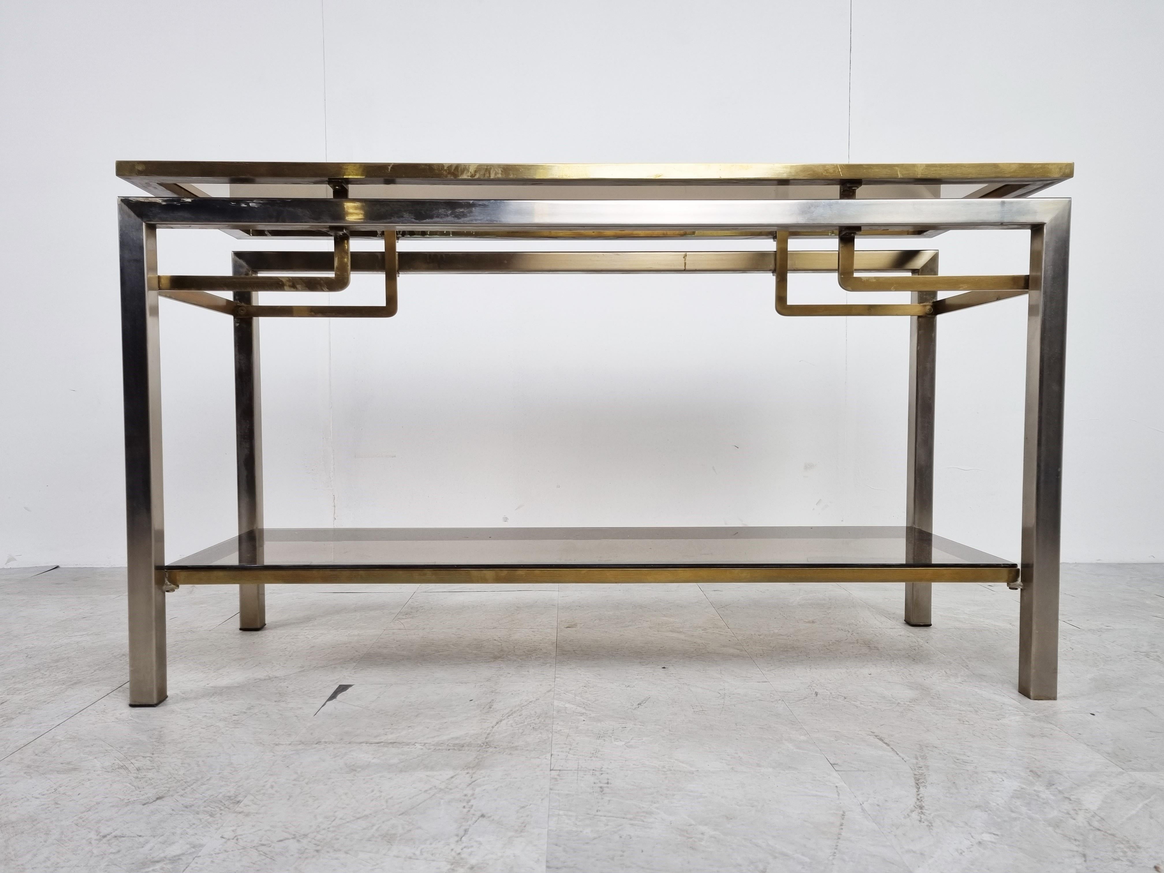 Vintage two tier brass and chrome console table with smoked glass

Good condition with normal age related wear. No faded brass or chips to the glass.

1970s - Belgium

Dimensions:
Height: 70cm/27.55