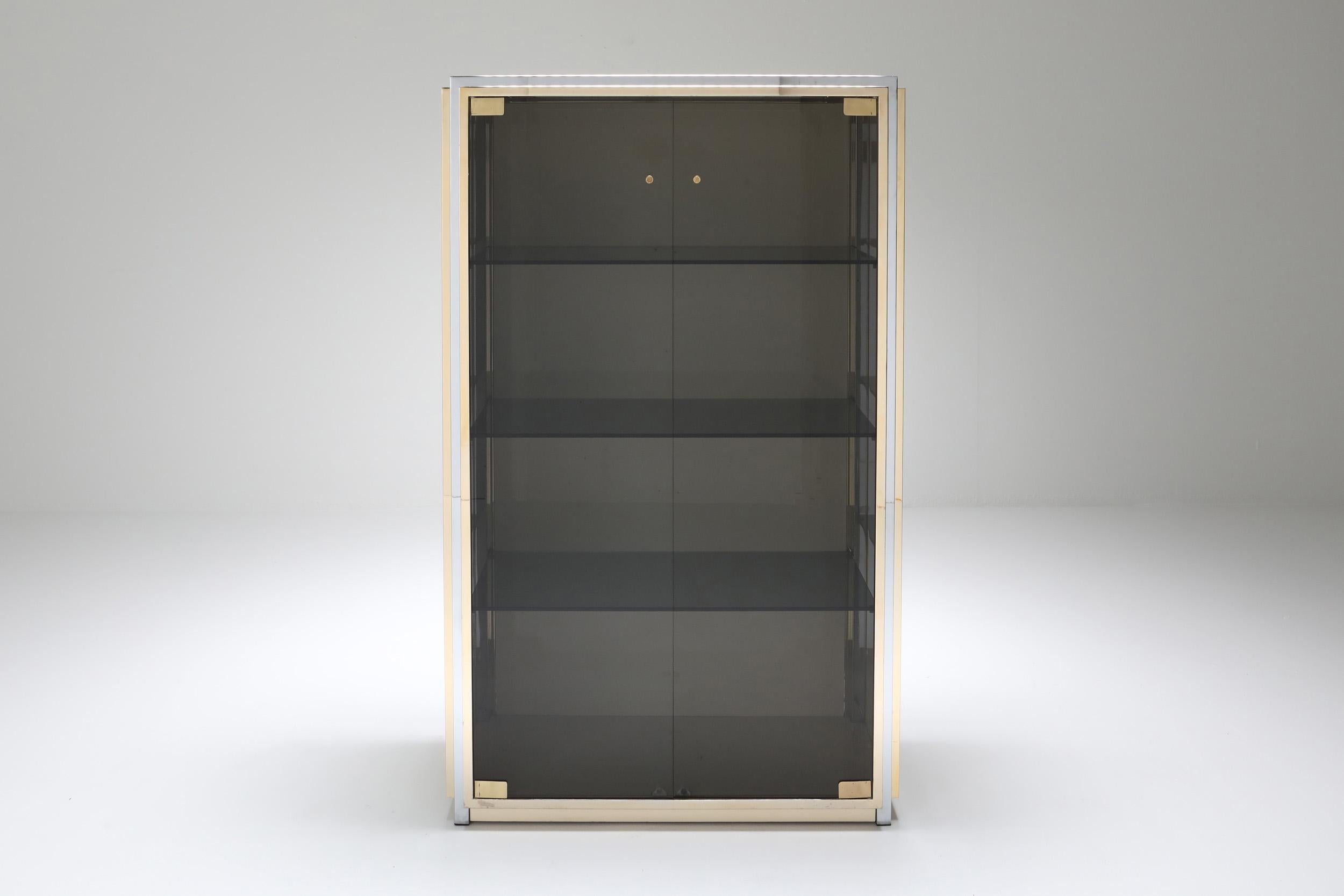 Renato Zevi showcase, Italy, 1970s.

Smoked glass doors with chrome and brass framing and crème lacquered side panels.
The cabinet is provided with three smoked glass shelves.
Measures: D 40, W 93, H 151 (between shelves 34) cm.
Would fit well