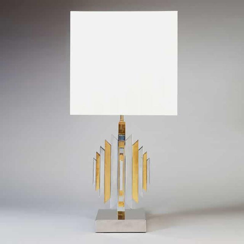 A Romeo Rega style table lamp in brass and chrome. Each face is decorated with chamfered end ascending length alternating panels of brass and chrome, Italy, circa 1975.

Height including the shade 32 ins (83cms).
 