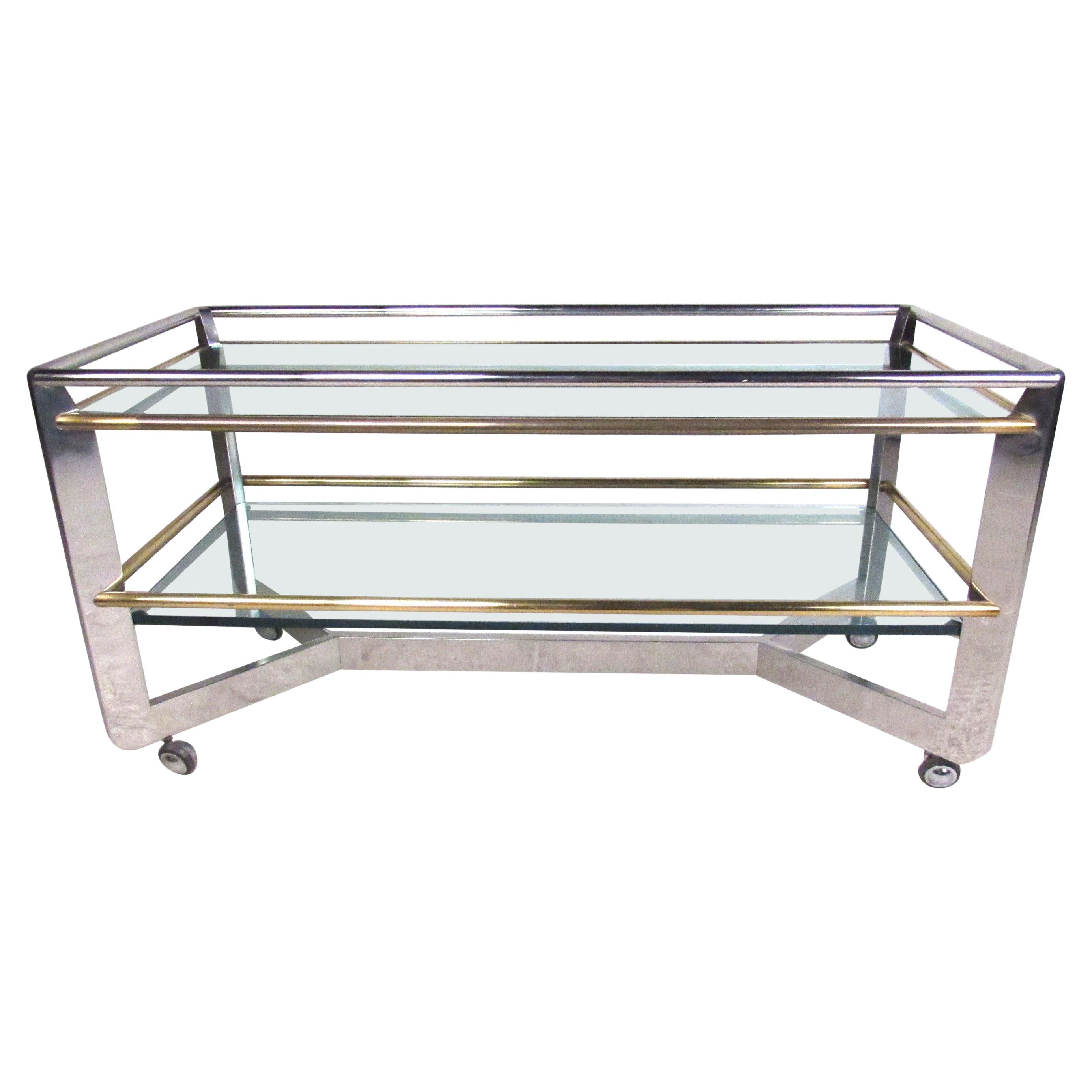High-quality two-tier cart ideal for use as a serving trolley or in a retail display setting. Features include heavy-duty chrome frame construction with brass railings, 3/4