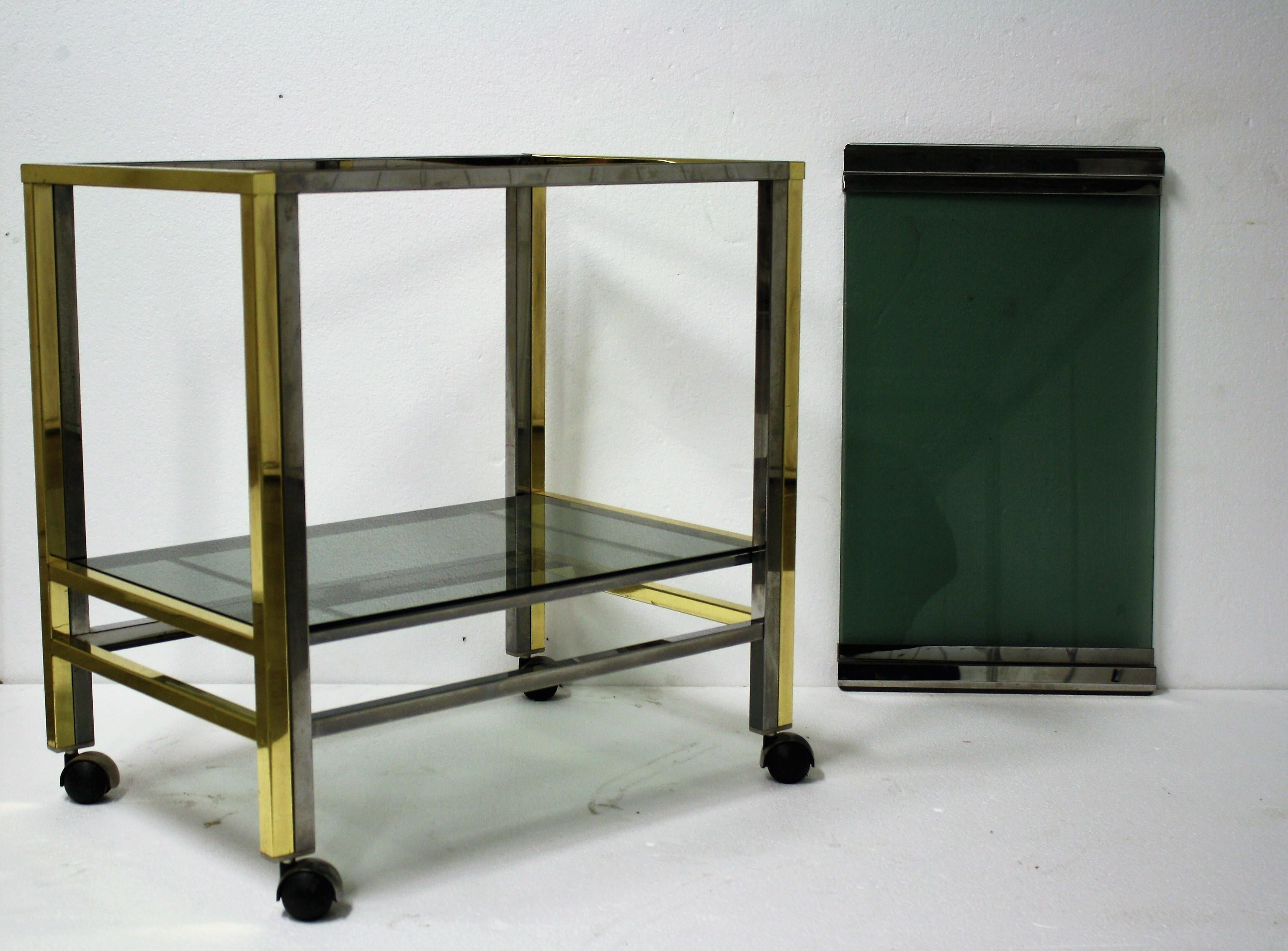 Brass and chrome two-tier serving trolley in the style of Romeo Rega.

Made of smoked glass and a removable tray at the top.

1970s, Italy

Dimensions:

Height 65cm/25.59