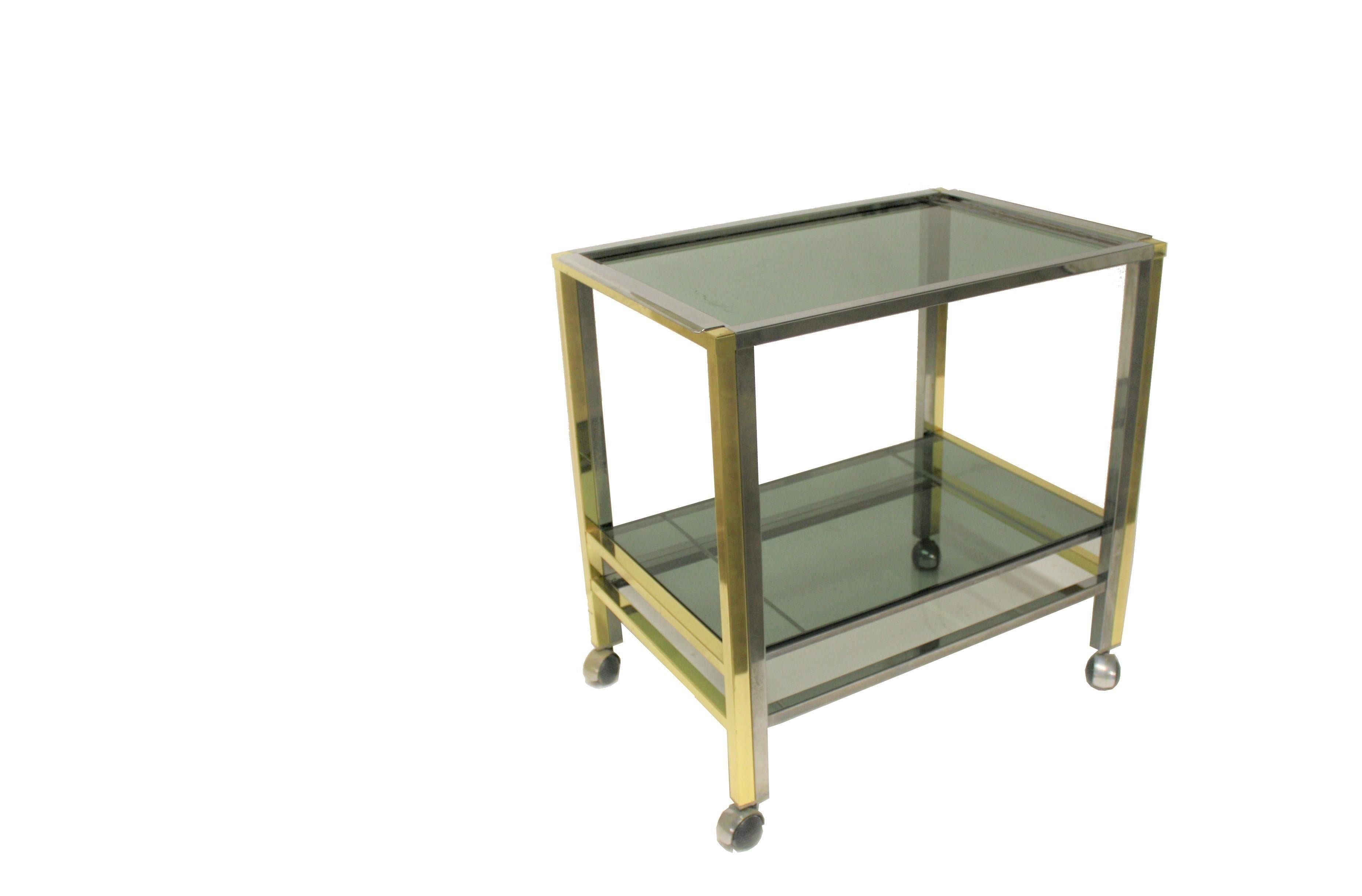 Brass and chrome two-tier serving trolley in the style of Romeo Rega.

Made of smoked glass and a removable tray at the top.

1970s, Italy

Dimensions:

Height 65cm/25.59