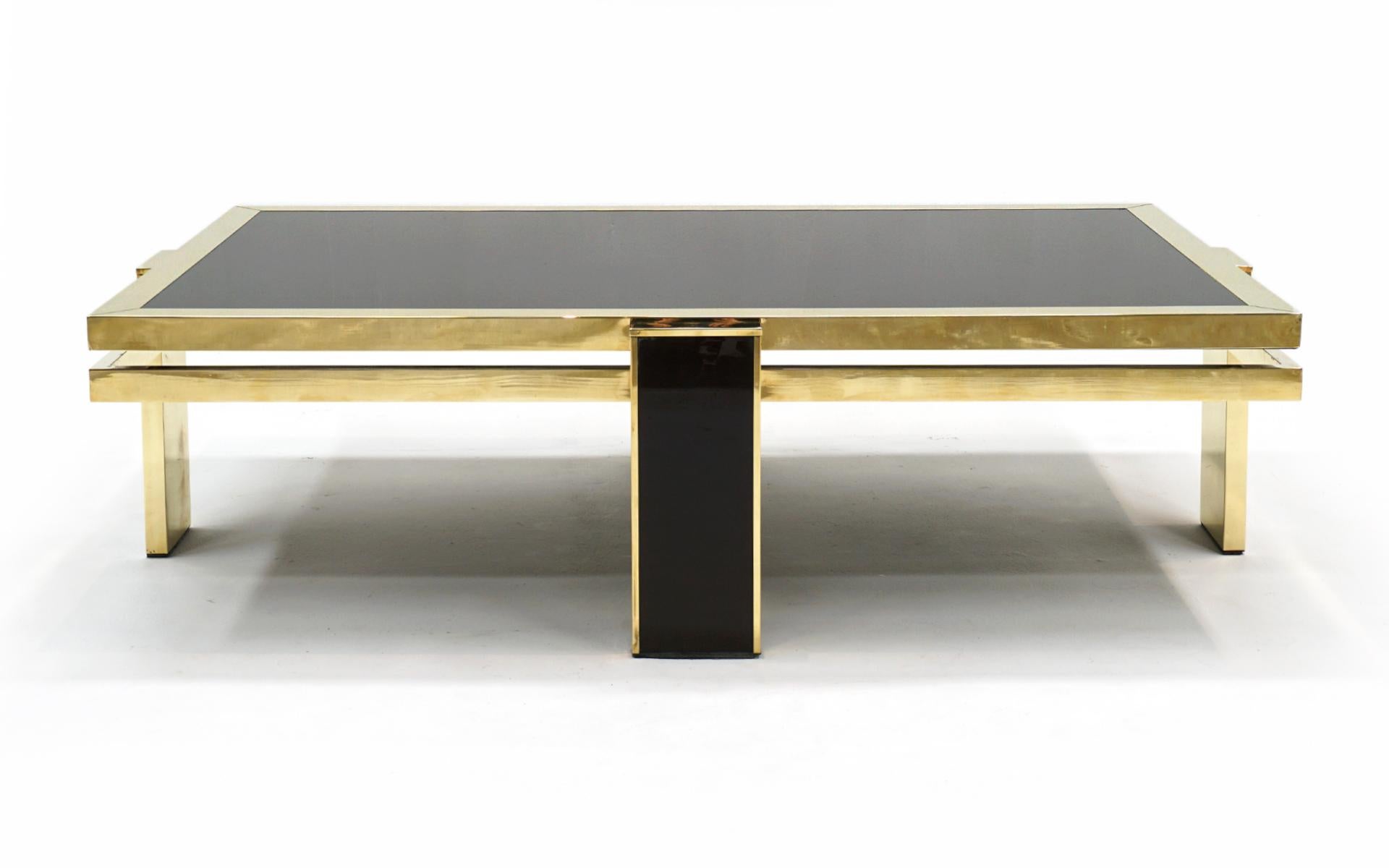 Large Solid brass and colored glass coffee table designed by Giacomo Sinopoli for Liwan's Rome 1970's. The solid brass frame has been professionally polished to a beautiful luster. The dark colored glass top is built in and completely supported on