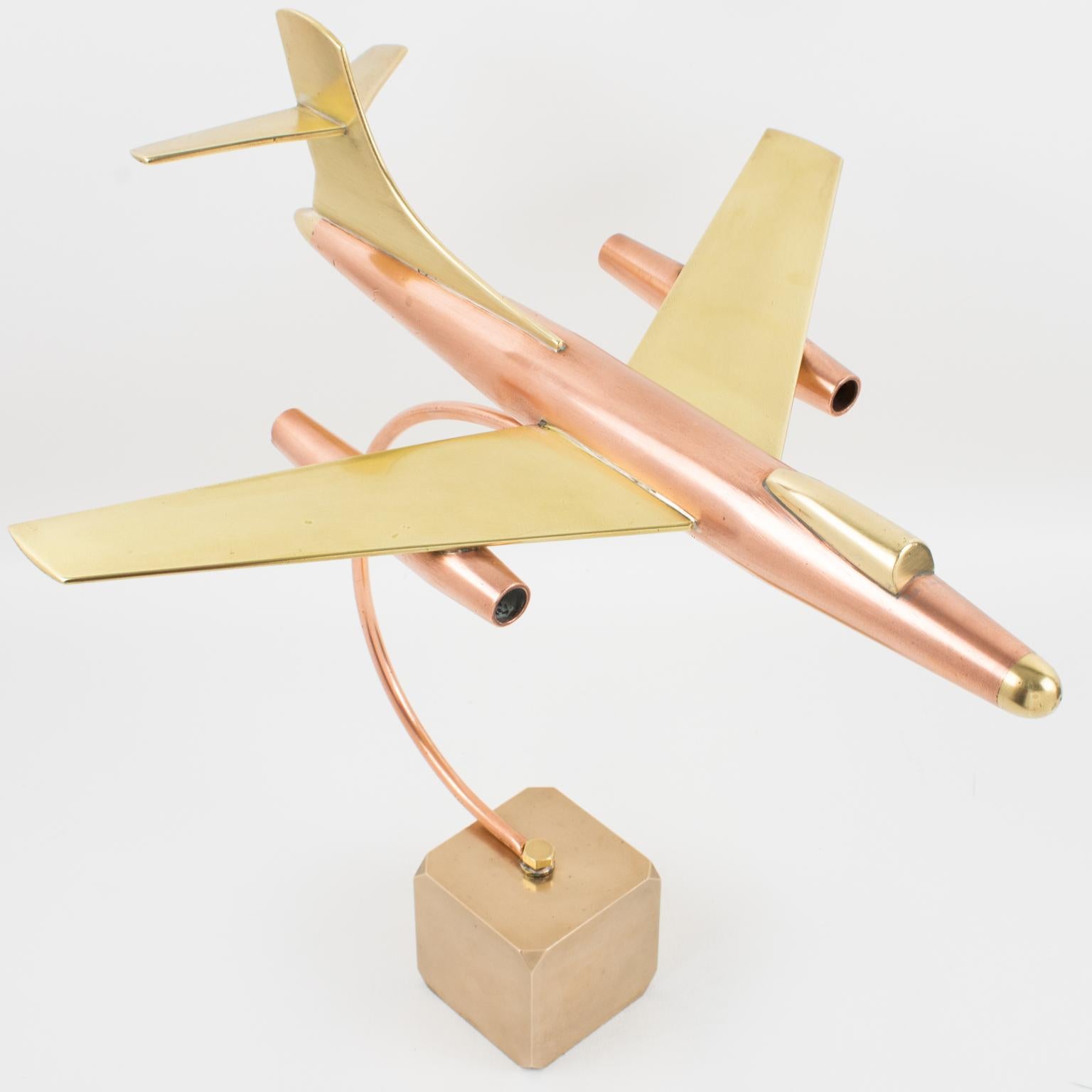 This is a stunning large brass and copper airplane model made in France circa 1960. The piece features an impressive all-metal jet plane model on a thick, solid brass cube base and is a great desk accessory for aviation collectors and lovers. There