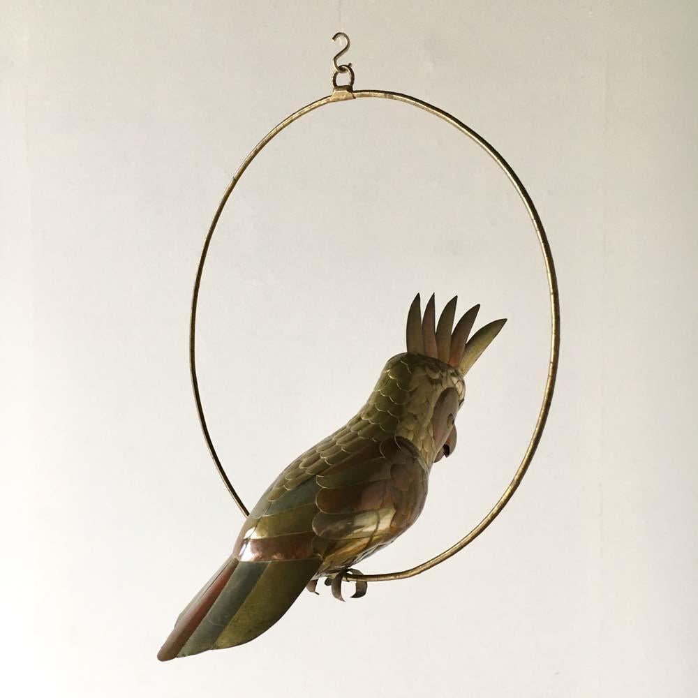 Copper and brass and aluminium cockatoo on a hoop hanging stand by Sergio Bustamante 1960s. 

Sergio Bustamante is a Mexican Artist and sculptor. He began with paintings and papier mache figures, inaugurating the first exhibit of his works at the