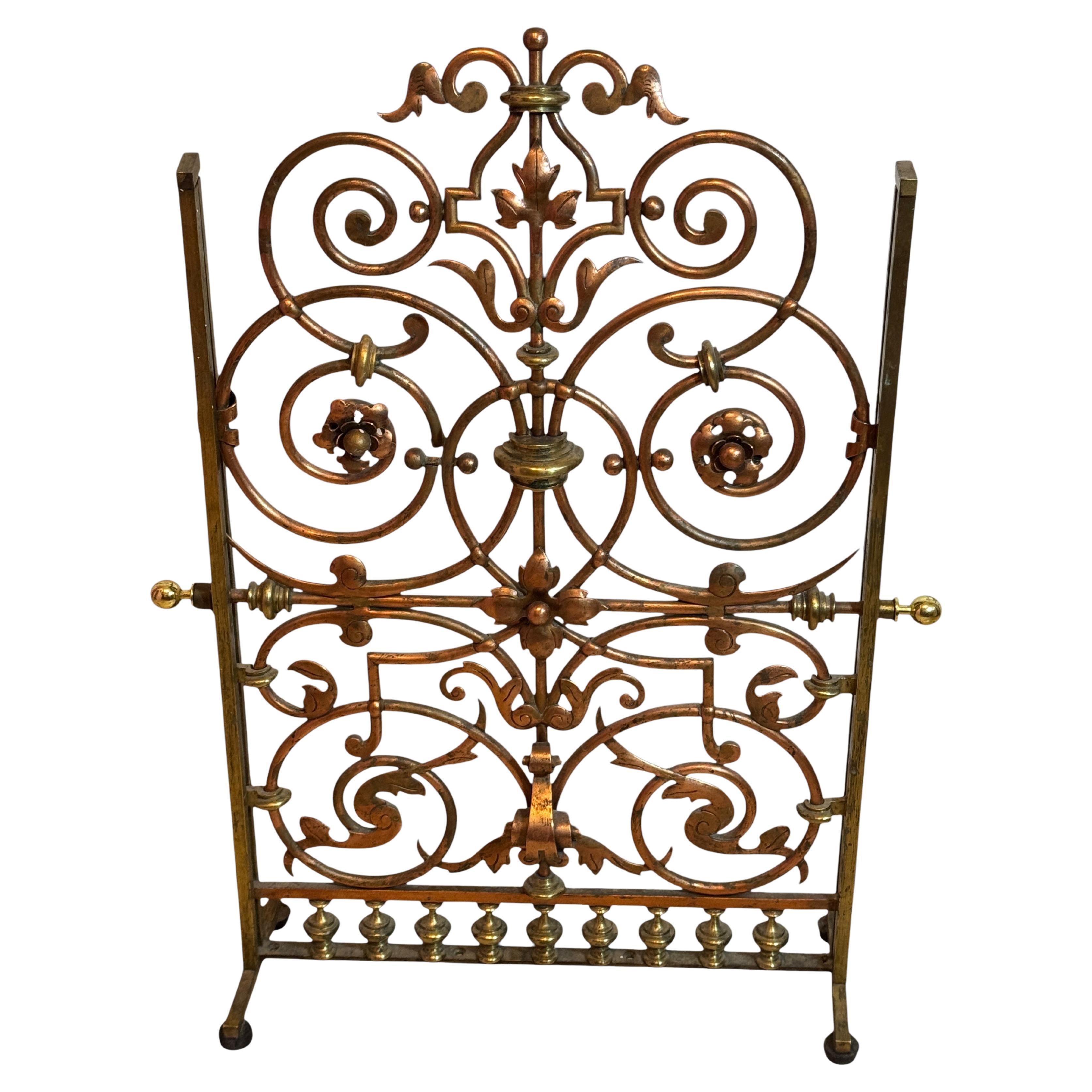 Petite grille de cheminée ornementale, 19e siècle. Cuivre et laiton dans les ornements floraux. Nouveaux boutons sur le côté, car les anciens étaient manquants. Traces d'âge. L'écran de cheminée est en laiton poli et en cuivre. État original tel que