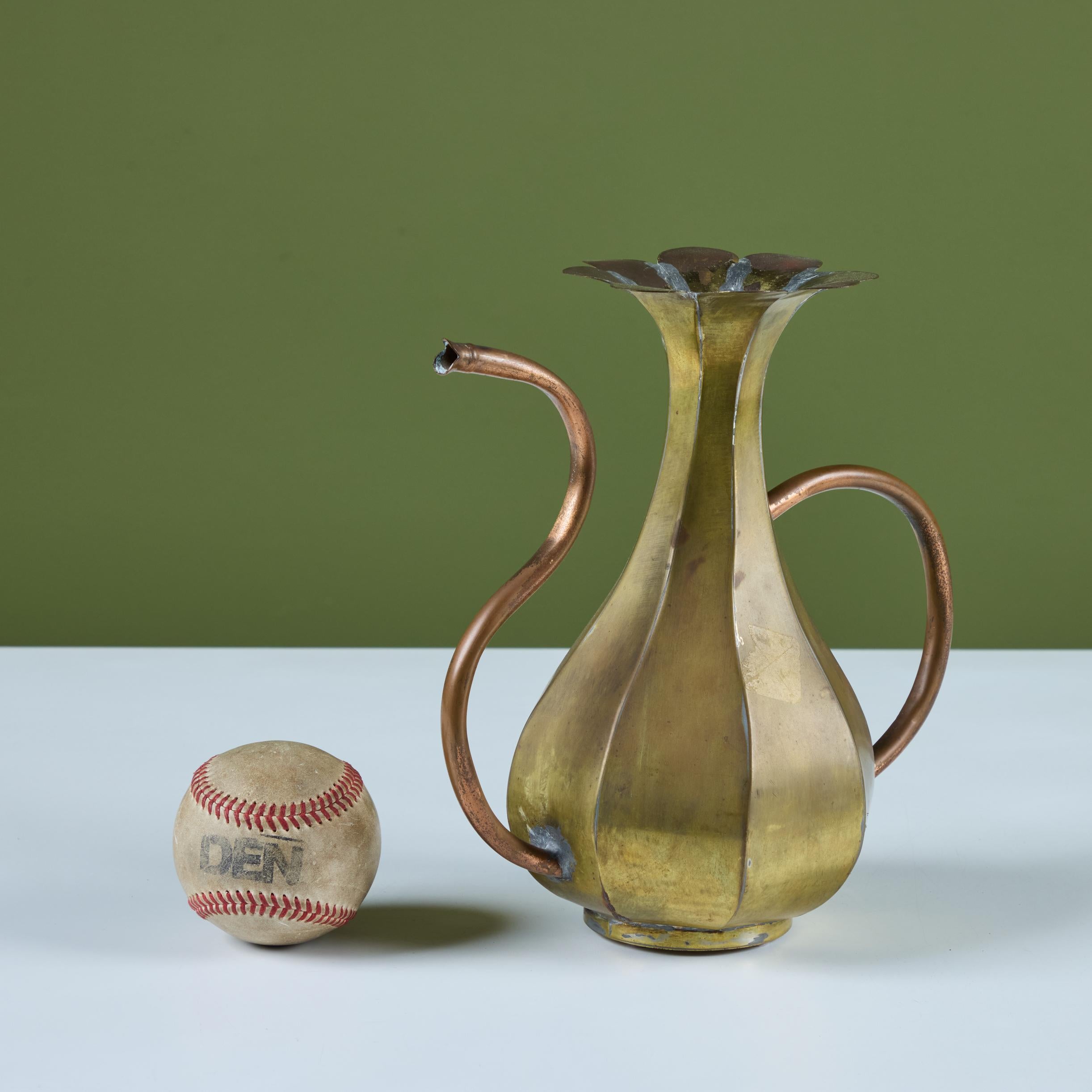 Brass and copper pitcher with floral opening. The pitcher features a brass body with eight sides. The spout and handle are made of copper tubing.


Dimensions
10” width x 5