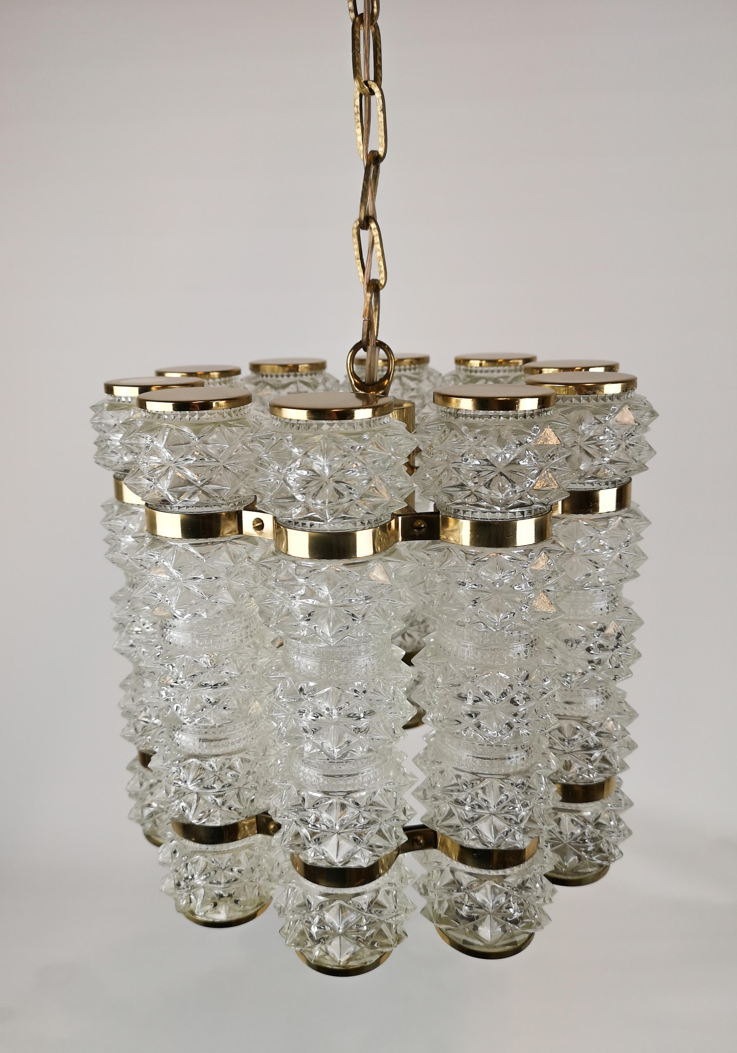 Well-made chandelier with ten cylinder shaped cupolas in crystallized glass and brass fittings.
Designed by Orrefors and manufactured by Tyringe, circa 1960 second half.

The lamp is in very good vintage condition with minor wear consistent with