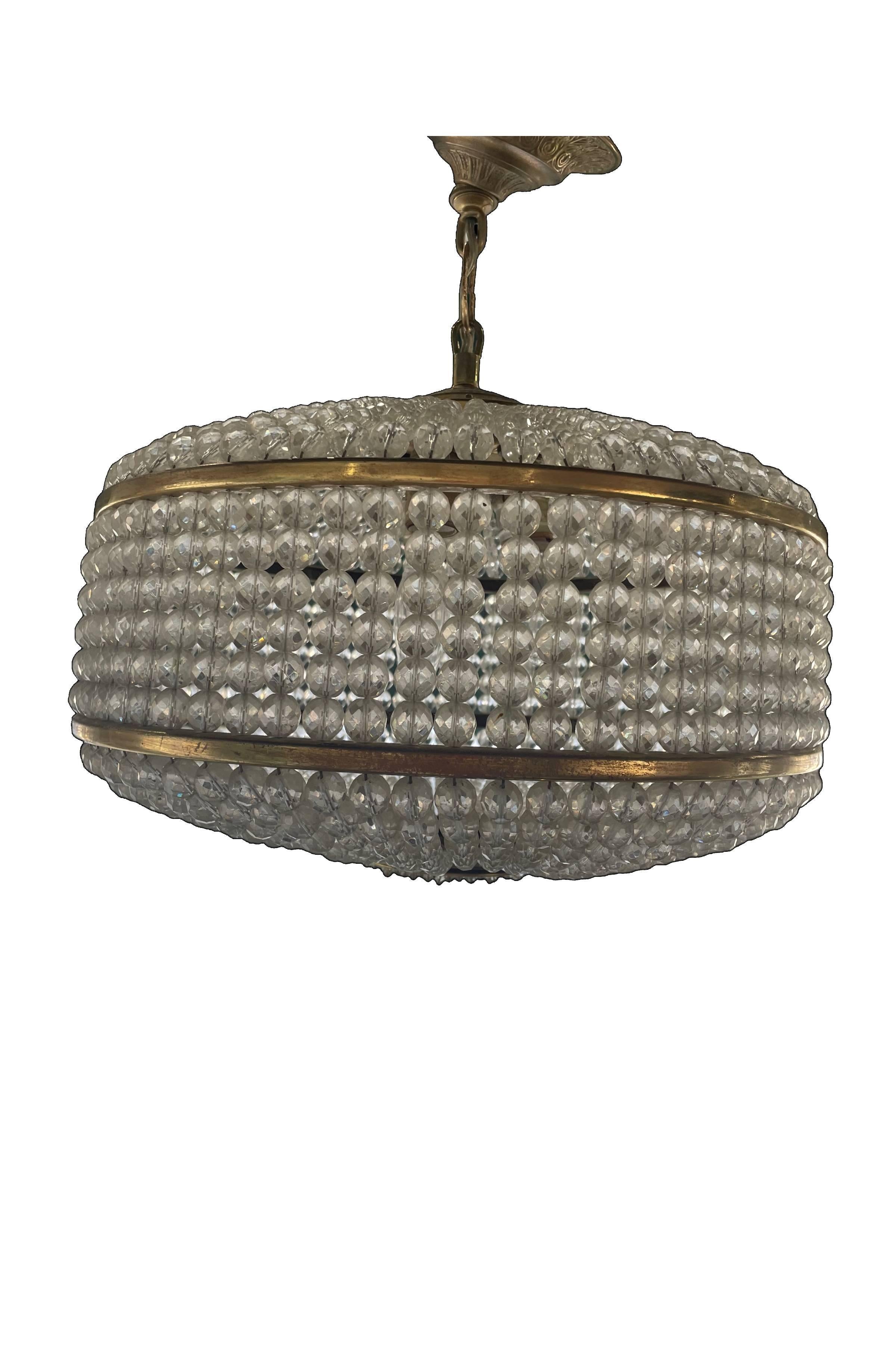 This Mid-Century Lobmeyr-style drum-shaped pendant fixture features hundreds of tightly, and, oh so symmetrically strung 3/4” to 1/8” glass crystals framed by two brass rings which form its base. A sparkling and elegant example of precise