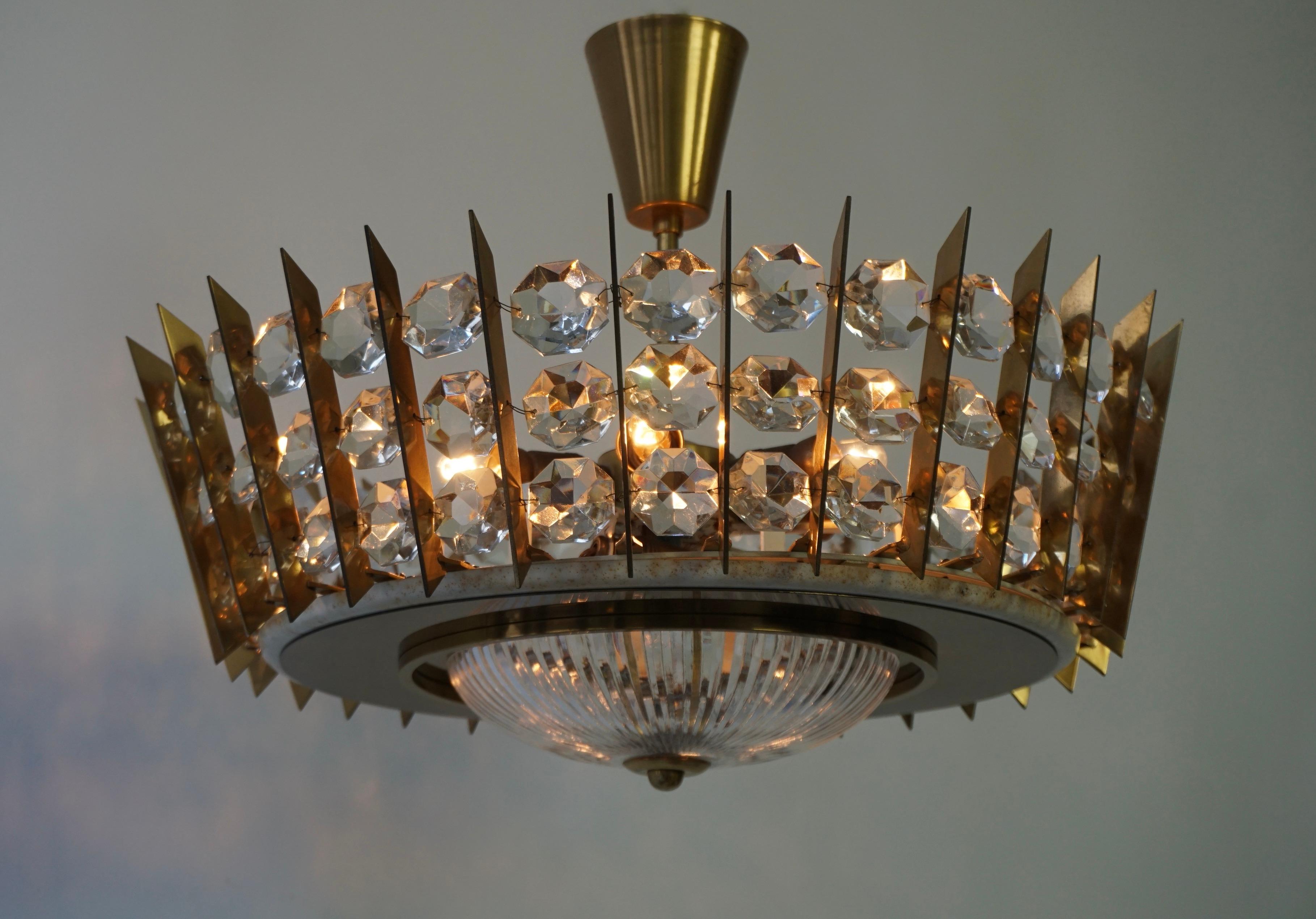 Amazing elegant flush mount or chandelier in crystal and brass. The piece shows a large quantity of brass elements, combined with crystal beads and thick faceted glass shapes.  

High quality and in very good condition. 

The fixture requires 8 x