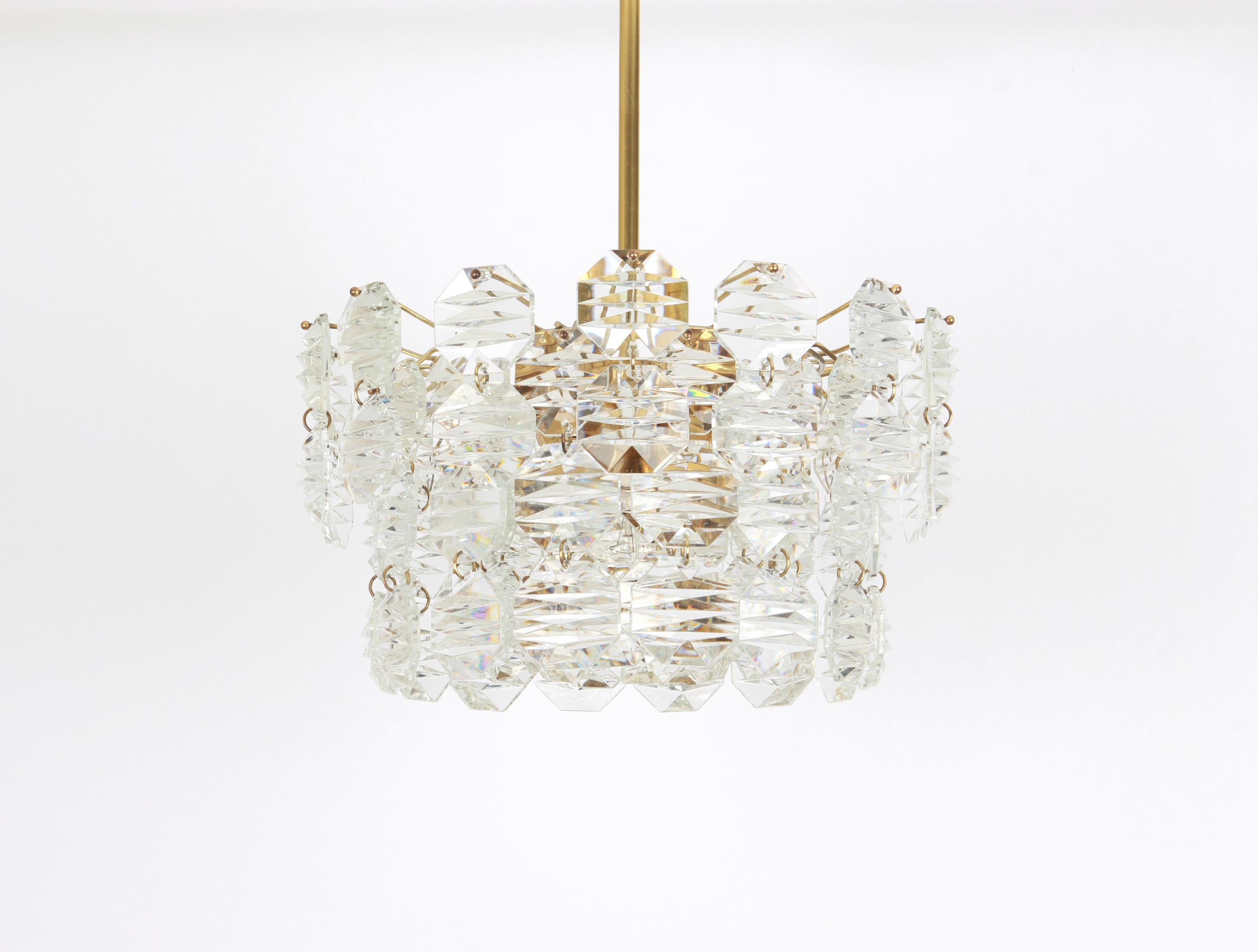 A stunning five-tier chandelier by Kinkeldey, Germany, manufactured in circa 1970-1979. A handmade and high quality piece. The chandelier features a brass frame with lots of facetted crystal glass elements.

High quality and in very good
