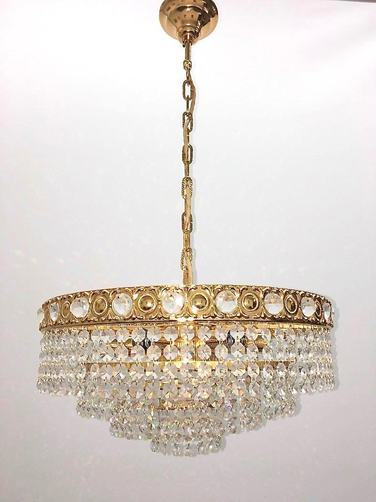 A beautiful 4-tiered brass and crystal glass chandelier made by Soelken Leuchten, Germany, 1960s. The chandelier requires six European E14 candelabra bulbs, each up to 40 watts. It is made of cut crystals and a brass frame.
This will look nice in