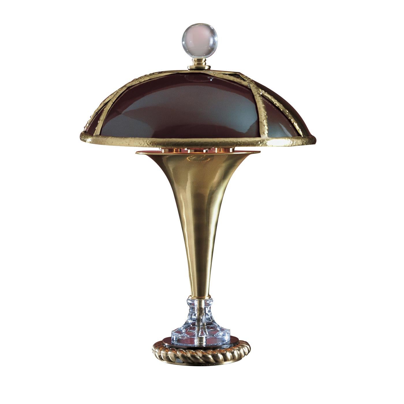 This magnificent table lamp features a structure in brushed brass and copper. The round base, with classically inspired decorations, is adorned with a Bohemian crystal element that will reflect the light coming from the three E27 bulbs (max 75W) to